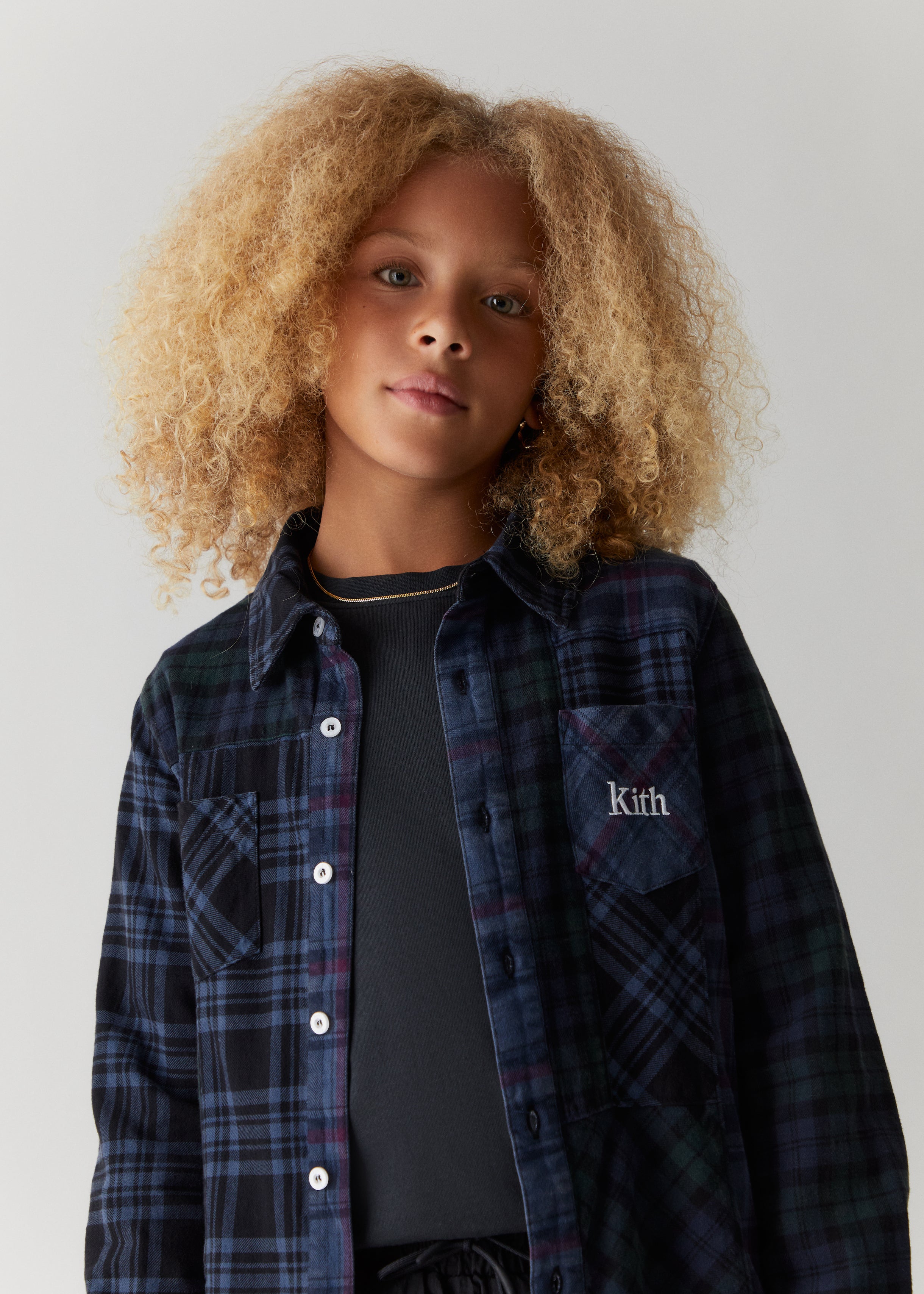 A child wearing a Kith-branded flannel shirt.