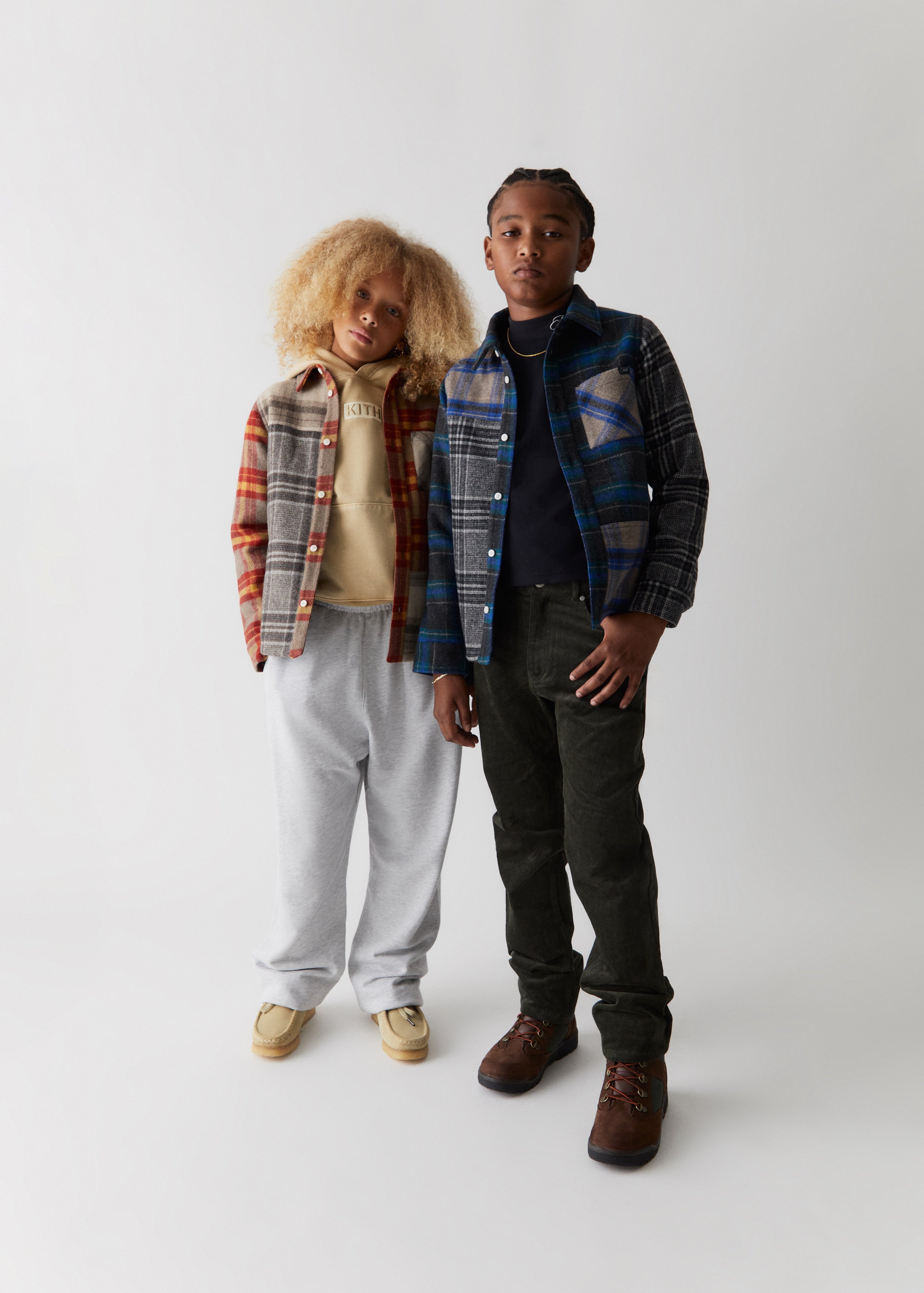 Two kids wearing flannel shirt jackets and sweatpants from Kith Kids Fall Classics 2023. 