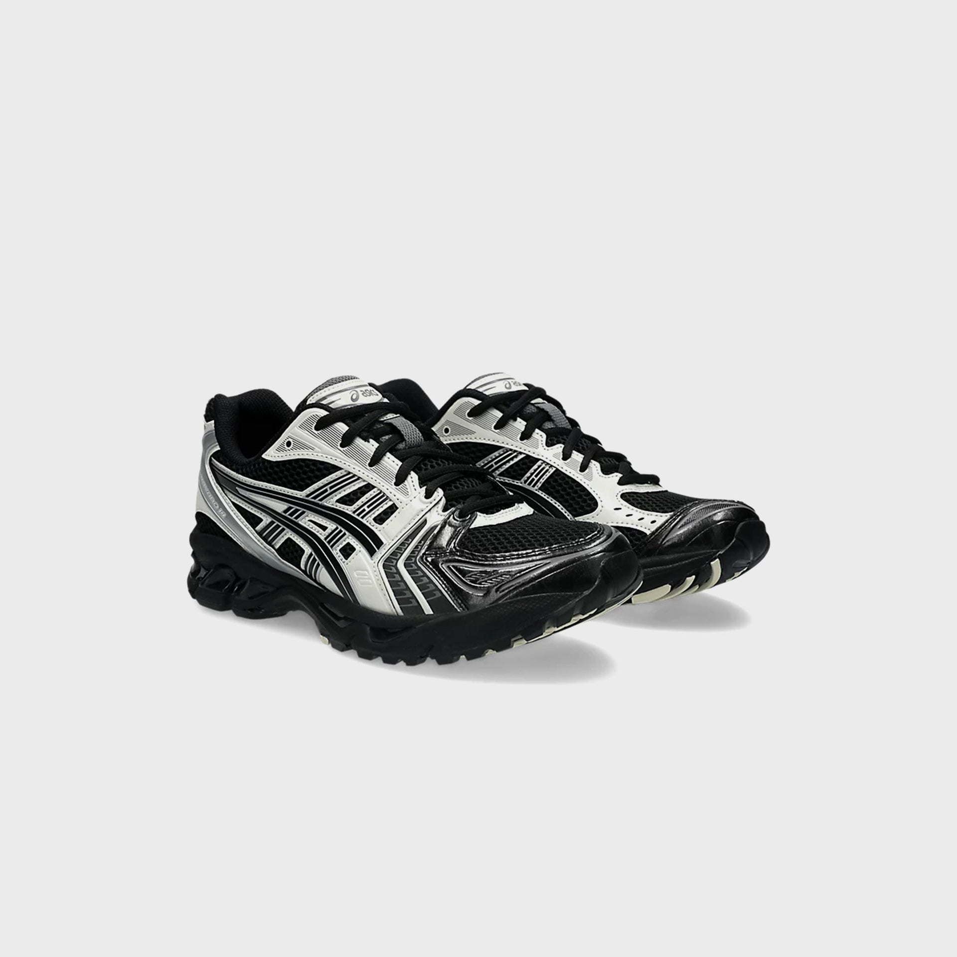 ASICS GEL-KAYANO 14 in Black and Cream, angled front view of the pair