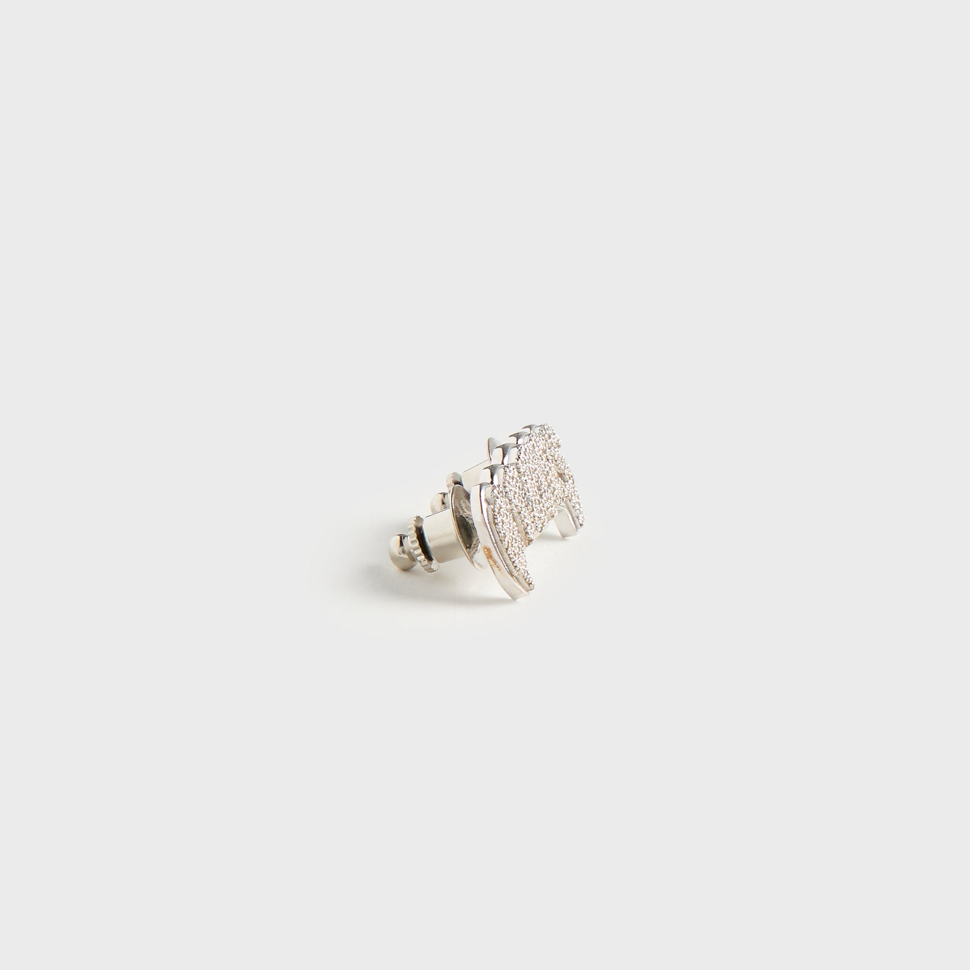 WTAPS x Grillz Jewelz Vamp silver badge, angled view showing pin backing