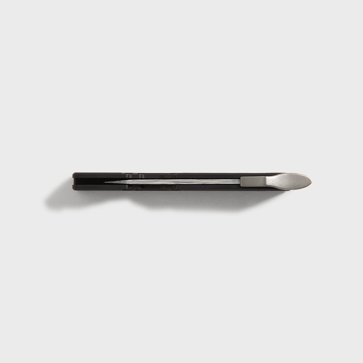 Top-down view of the Kith x Benchmade Yamori Black knife showing the pocket clip and folded Damascus blade in profile