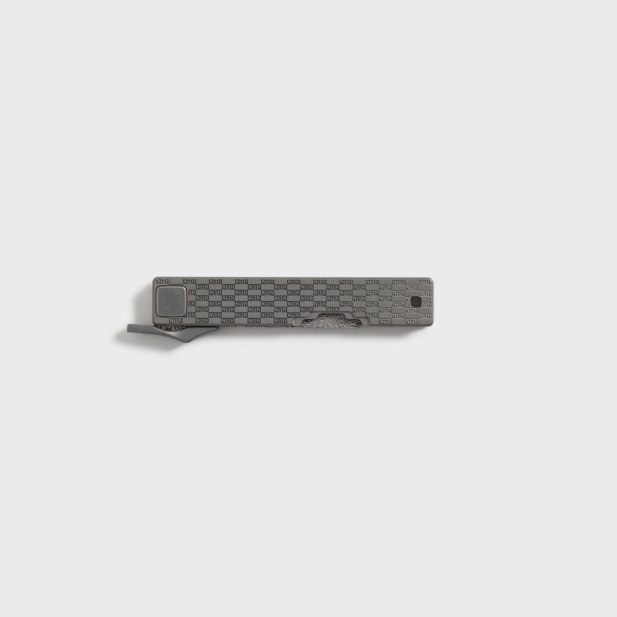 Kith x Benchmade Yamori Drift knife closed, pocket clip and Damascus blade tip showing along the gunmetal grey handle