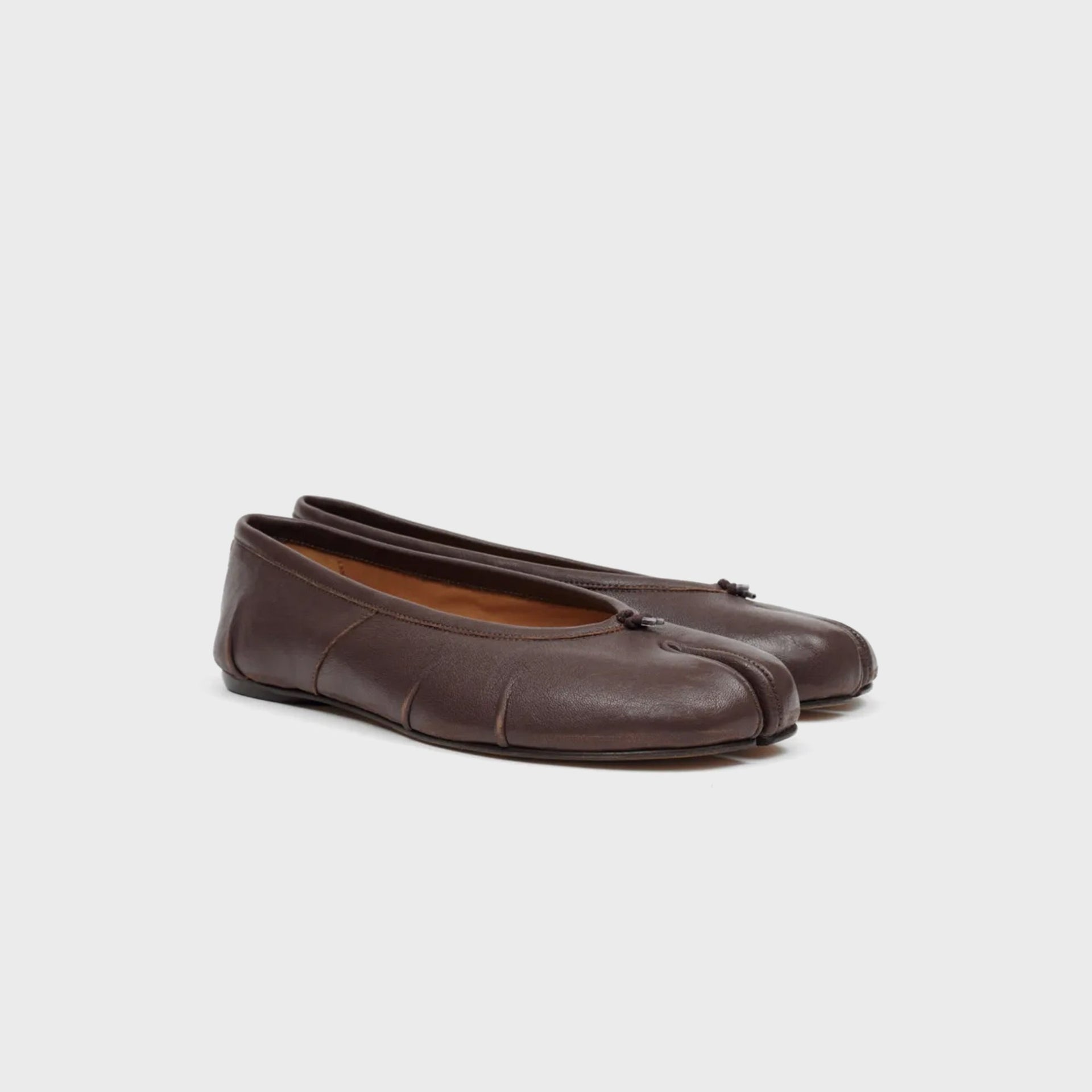 Pair of Maison Margiela WMNS Tabi ballerina flats in brown leather, three-quarter front view showing split-toe silhouette