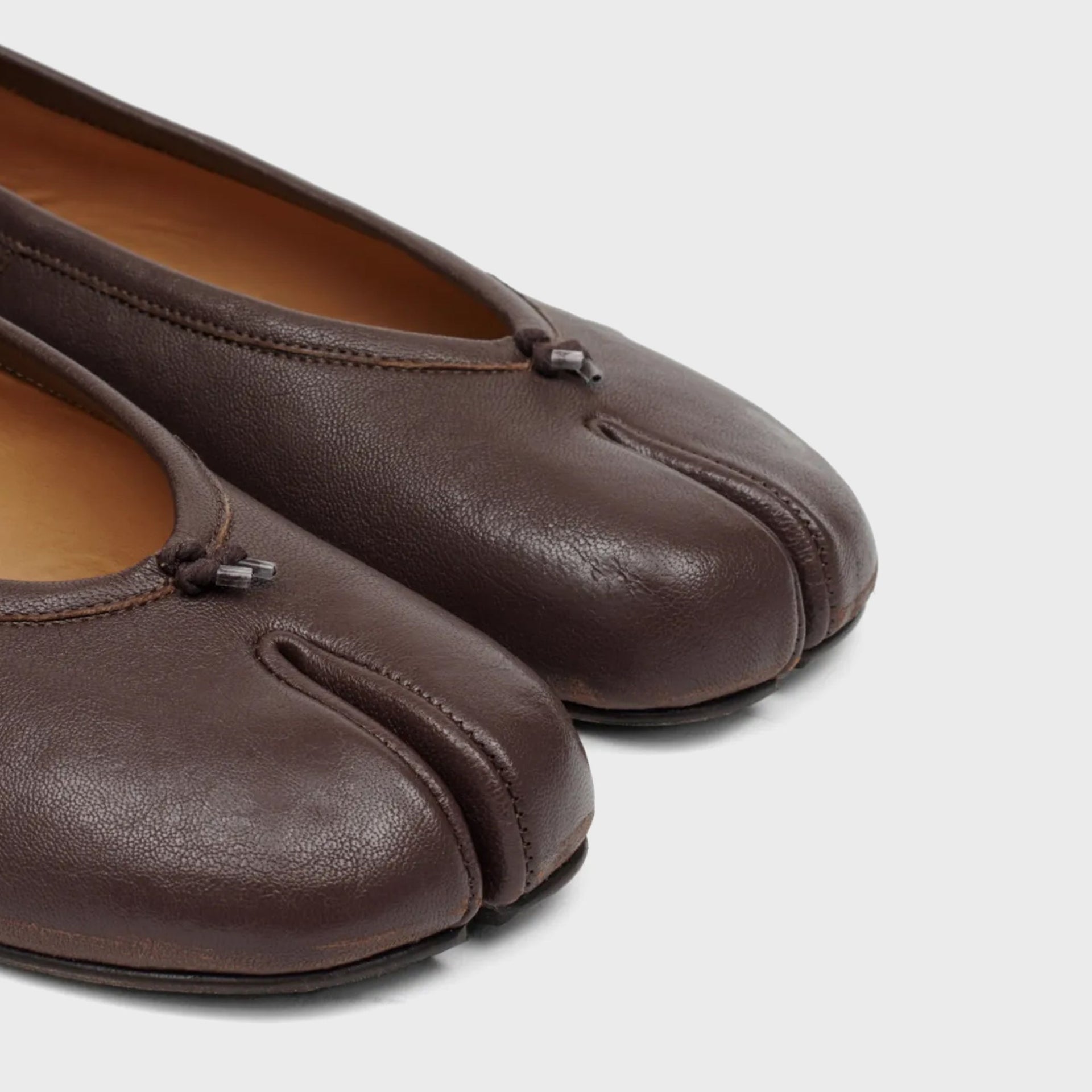 Close-up of Maison Margiela WMNS Tabi ballerina flats in brown leather showing the split cloven toe seam and tan lining