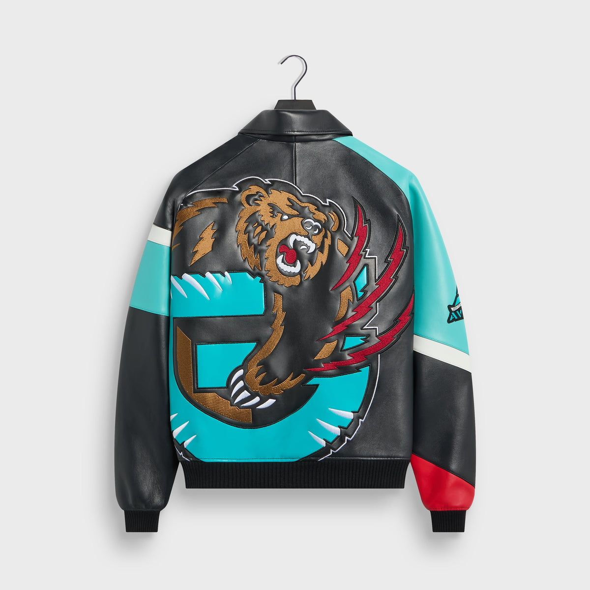 Kith & AVIREX Vancouver Grizzlies leather jacket, back view with large embroidered brown bear and teal G logo on hanger