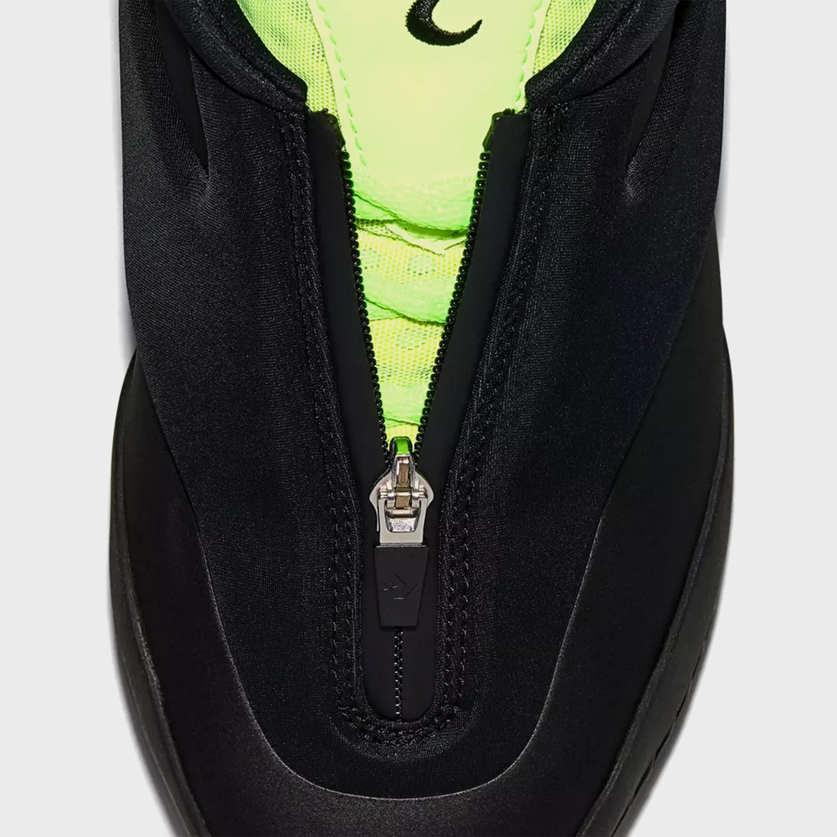 Close-up of Converse SHAI 001 Ox front zip pull with green mesh tongue detail