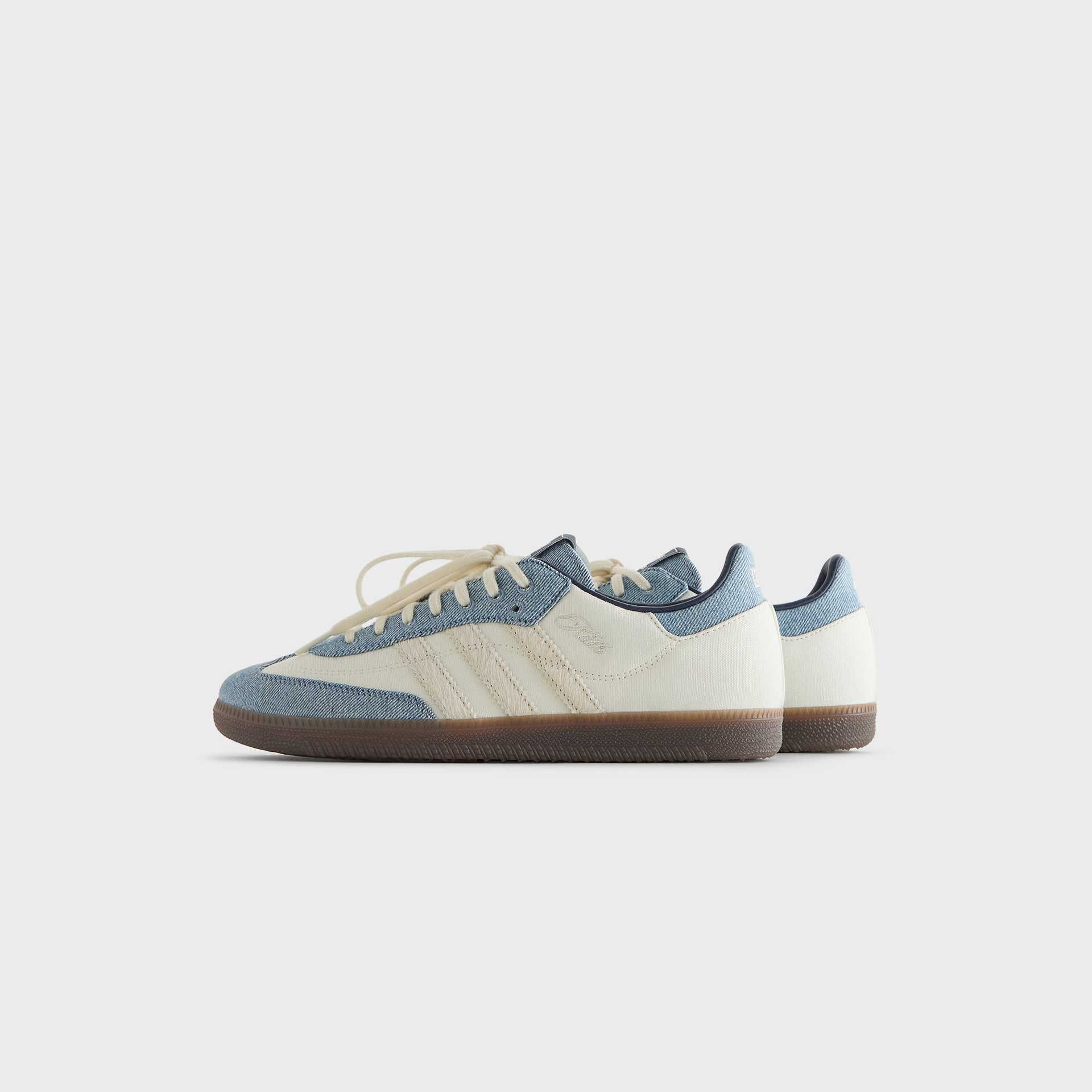 Kith for adidas Originals Samba sneakers in Denim/White, angled side view of the pair against a light gray background