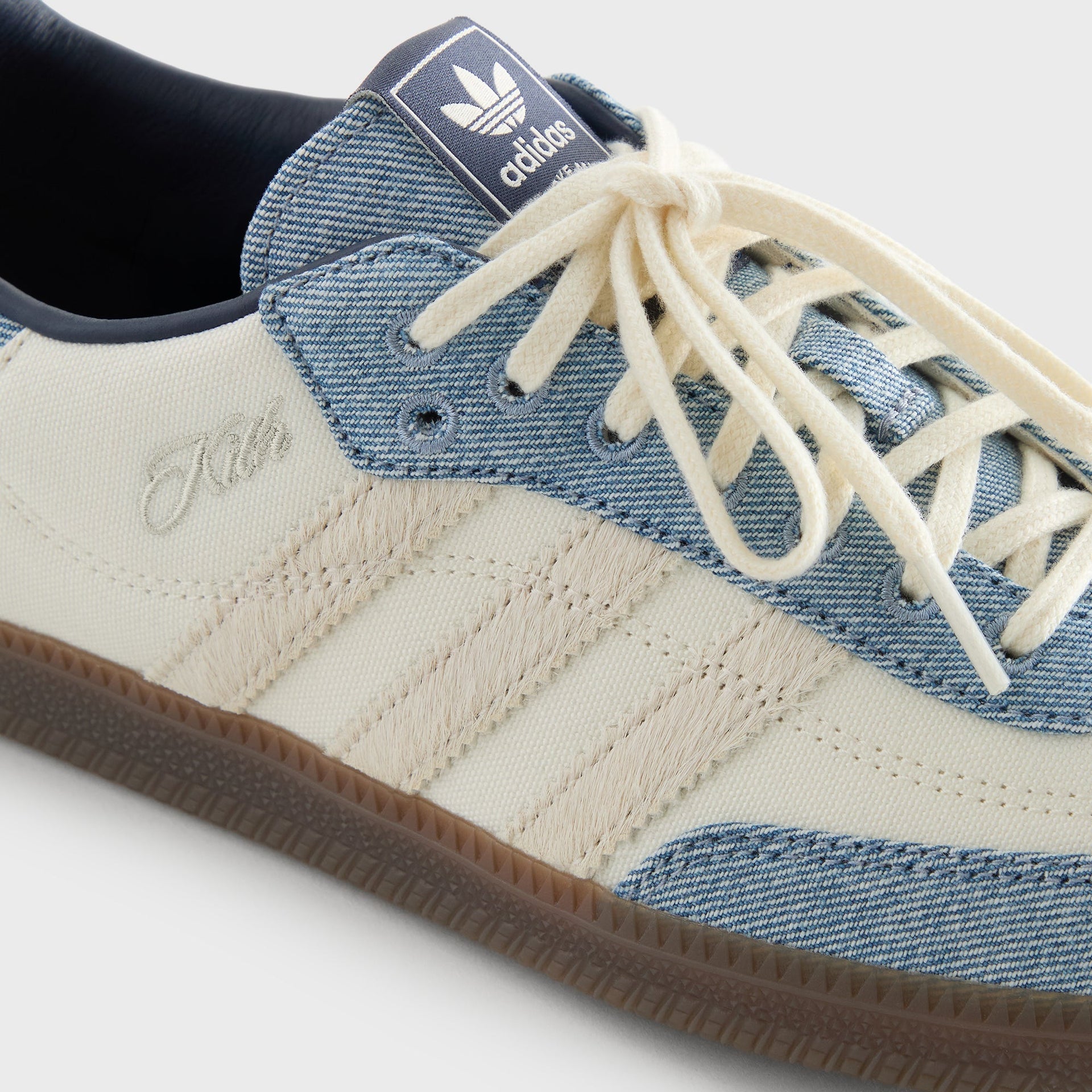Close-up of the Kith for adidas Originals Samba Denim/White quarter panel, showing the cream Kith script logo and adidas stripes