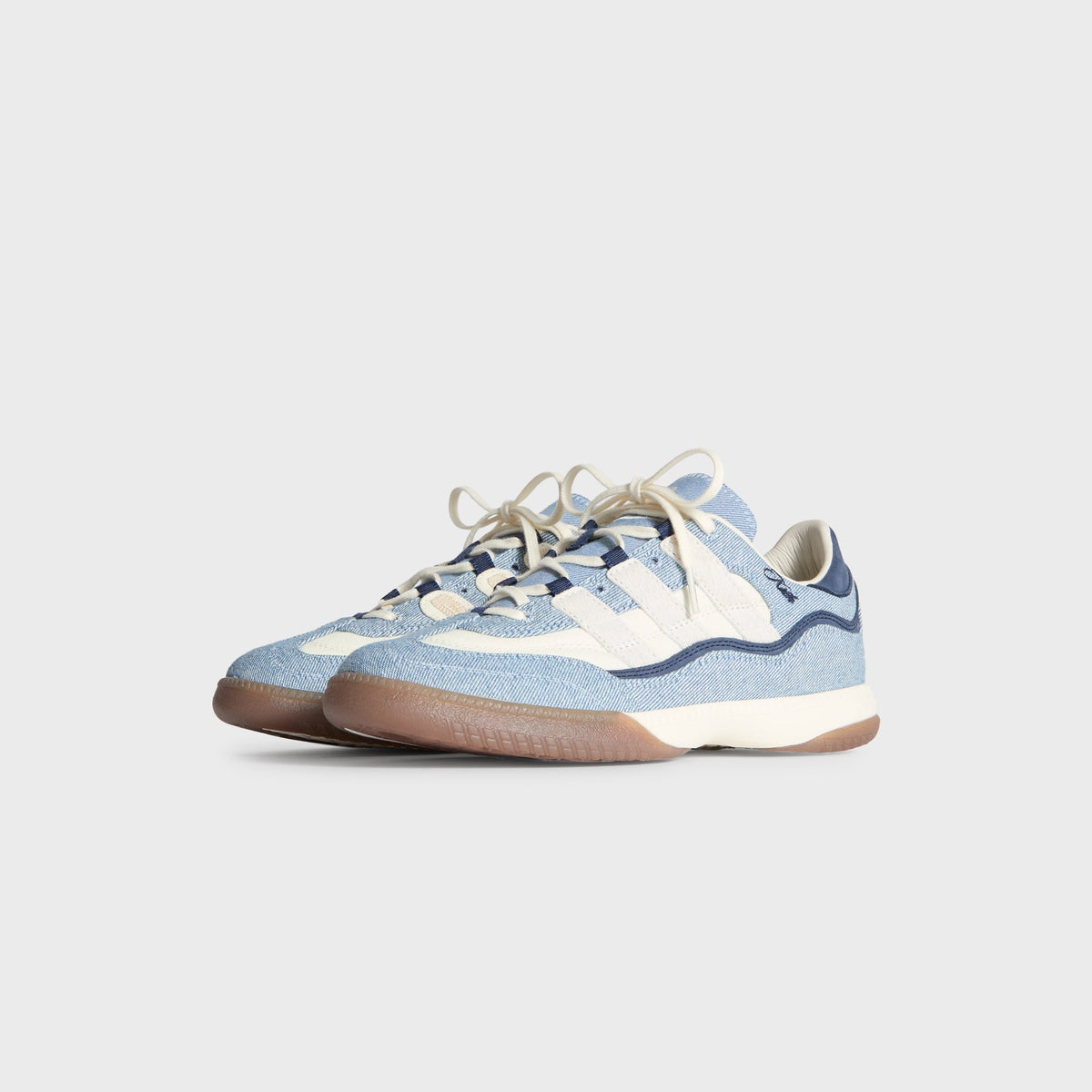 Kith for adidas Football Supernova Indoor in Denim/Gum, front three-quarter view of the light-blue denim pair with cream stripes