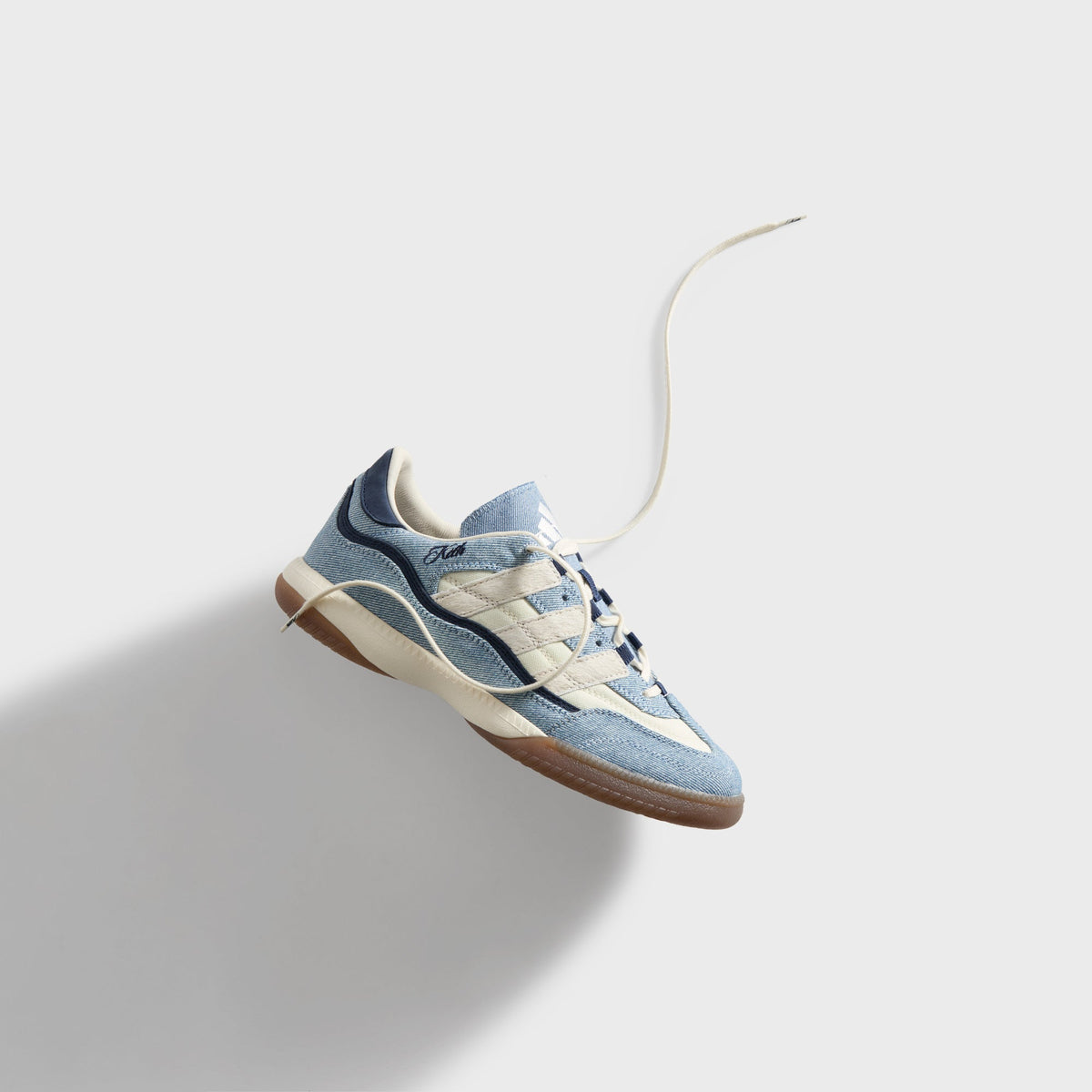 Kith for adidas Football Supernova Indoor in Denim/Gum, single denim sneaker floating with an extended lace on a grey background