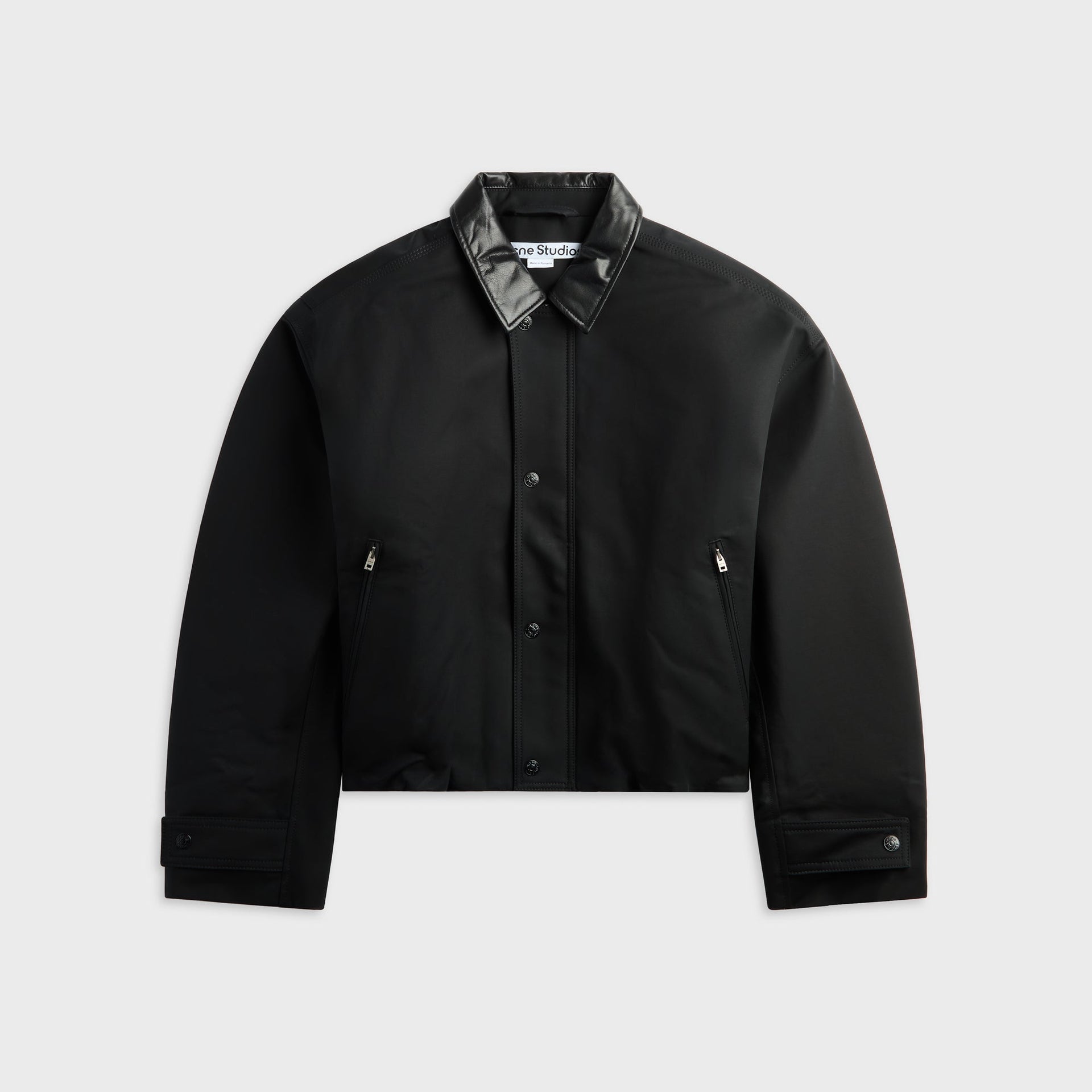 Acne Studios black bomber jacket with leather collar, front view, snap-button placket and zip pockets, flat lay