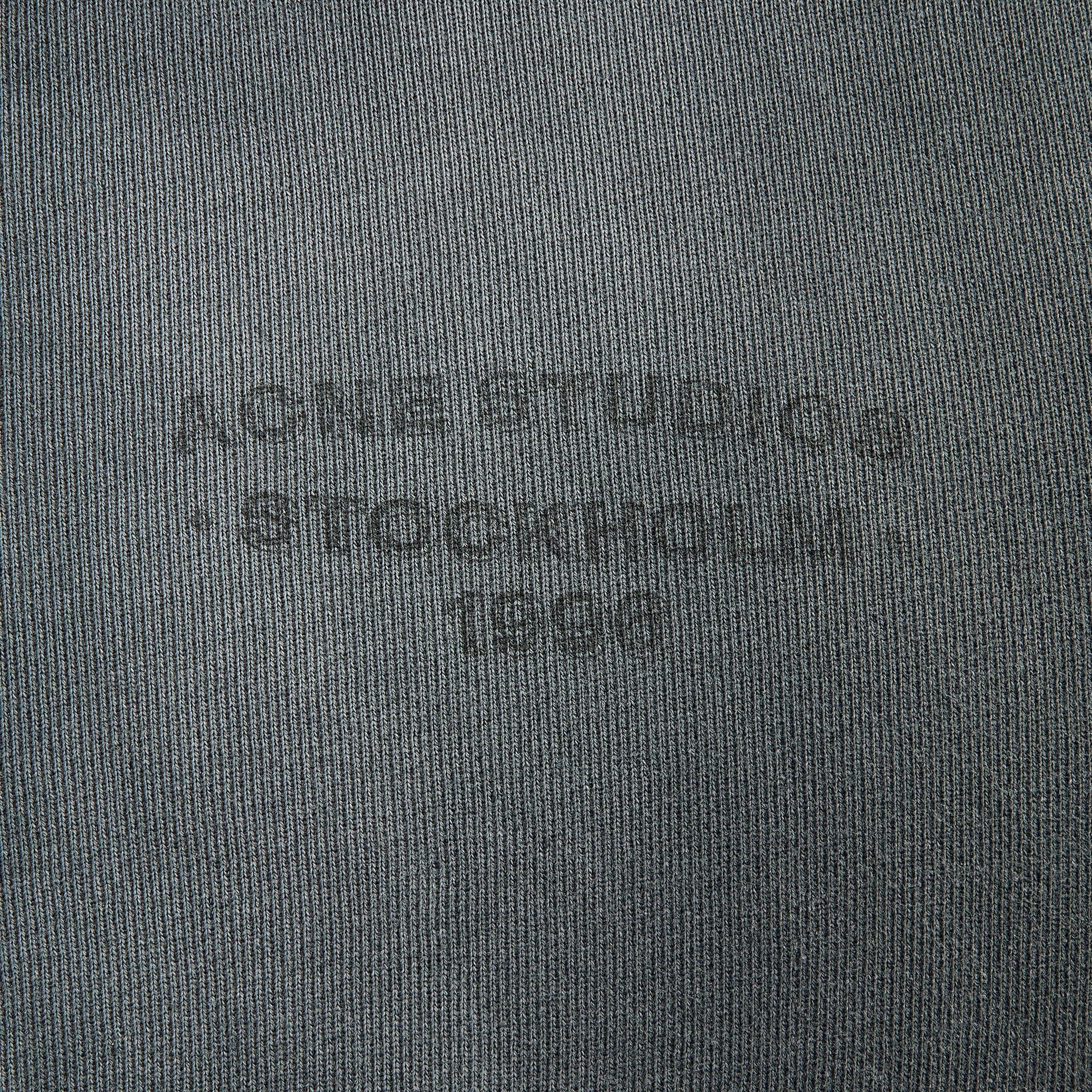 Acne Studios faded black zip hoodie fabric detail, close-up of tonal embossed logo on fleece