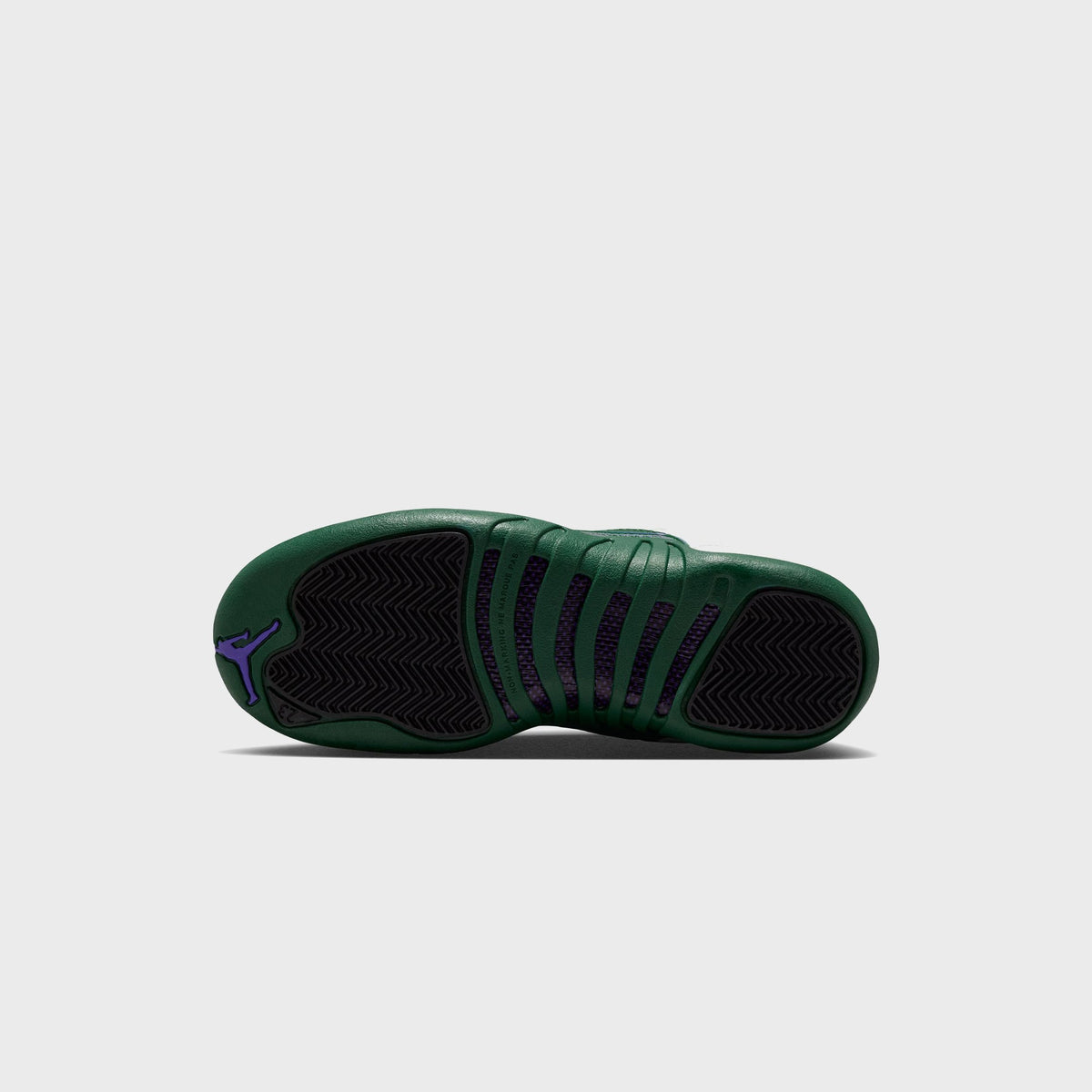 Outsole view of Jordan GS Air Jordan 12 Retro showing Gorge Green rubber sole with purple Jumpman logo and herringbone traction