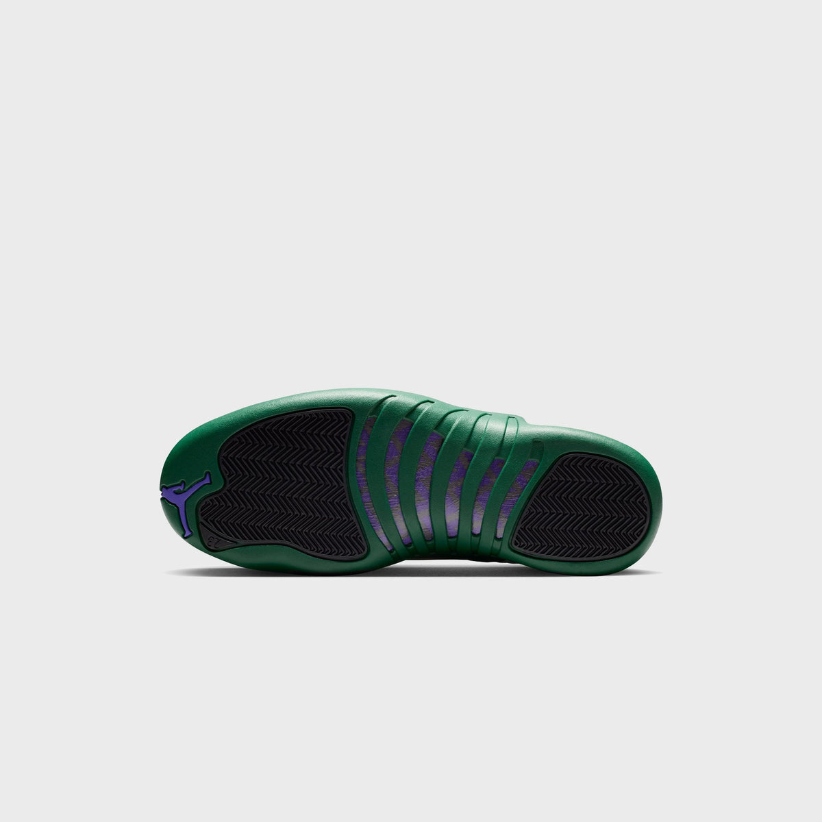 Outsole view of Air Jordan 12 Retro showing Gorge Green rubber sole with purple Jumpman logo and herringbone traction
