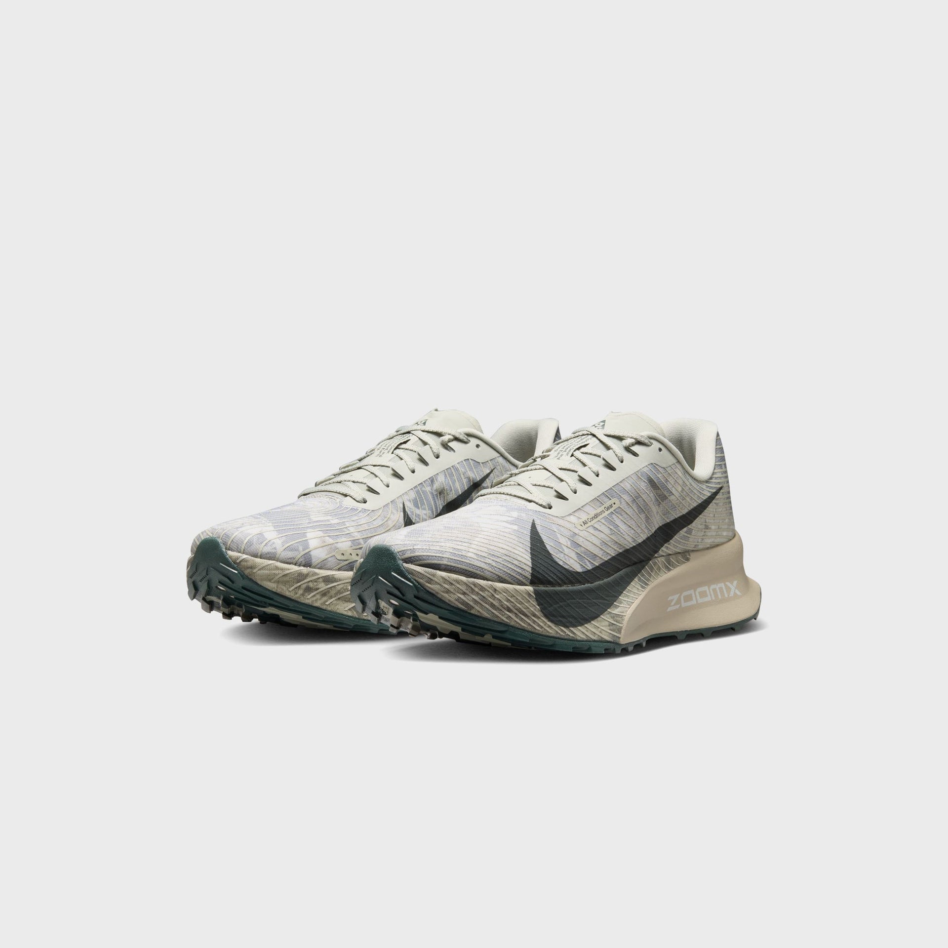 Pair of Nike ACG Ultrafly Trail running shoes in spruce fog camo, front three-quarter view showing lugged black spruce outsoles