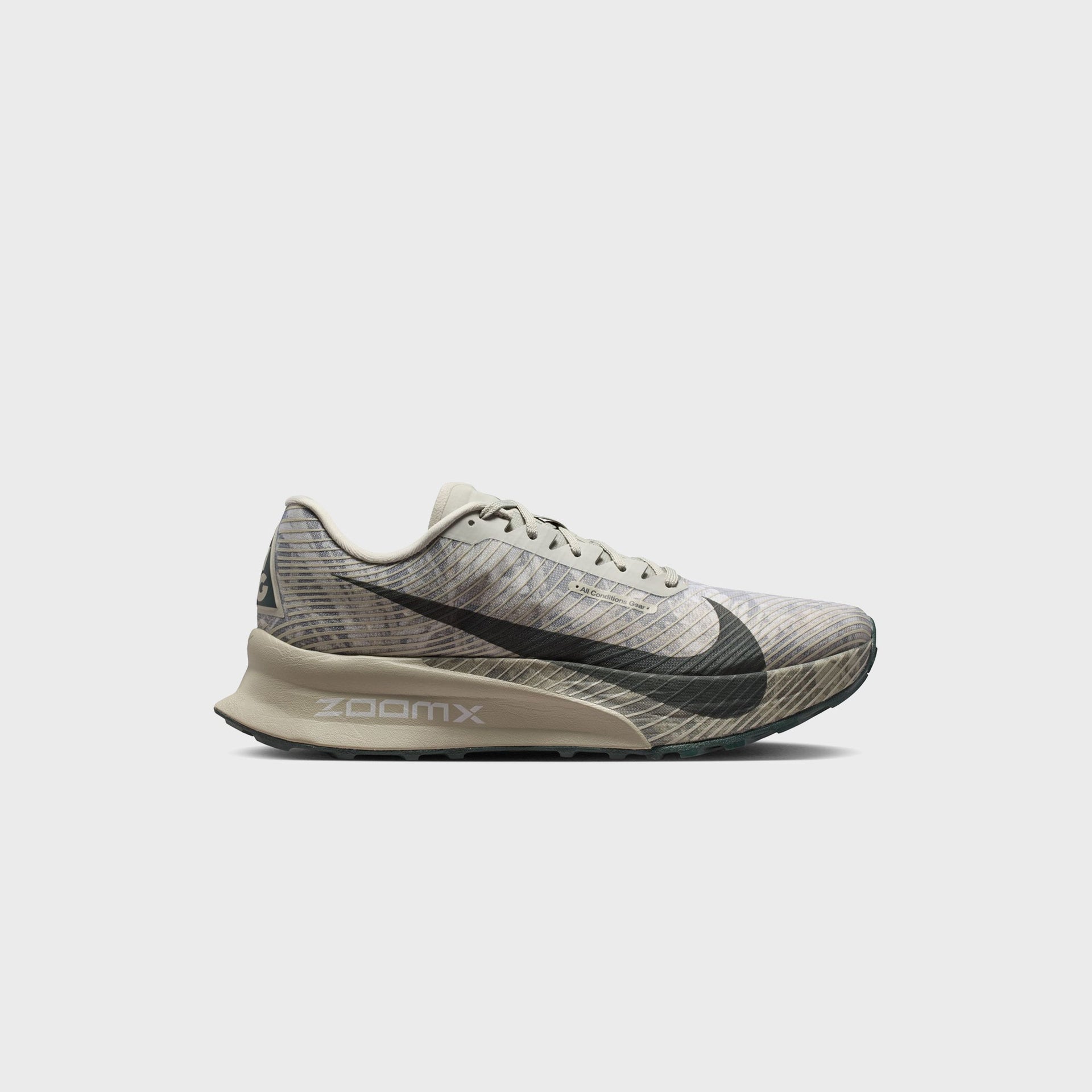 Nike ACG Ultrafly Trail running shoe in spruce fog camo print, lateral side view with dark green swoosh and tan ZoomX midsole