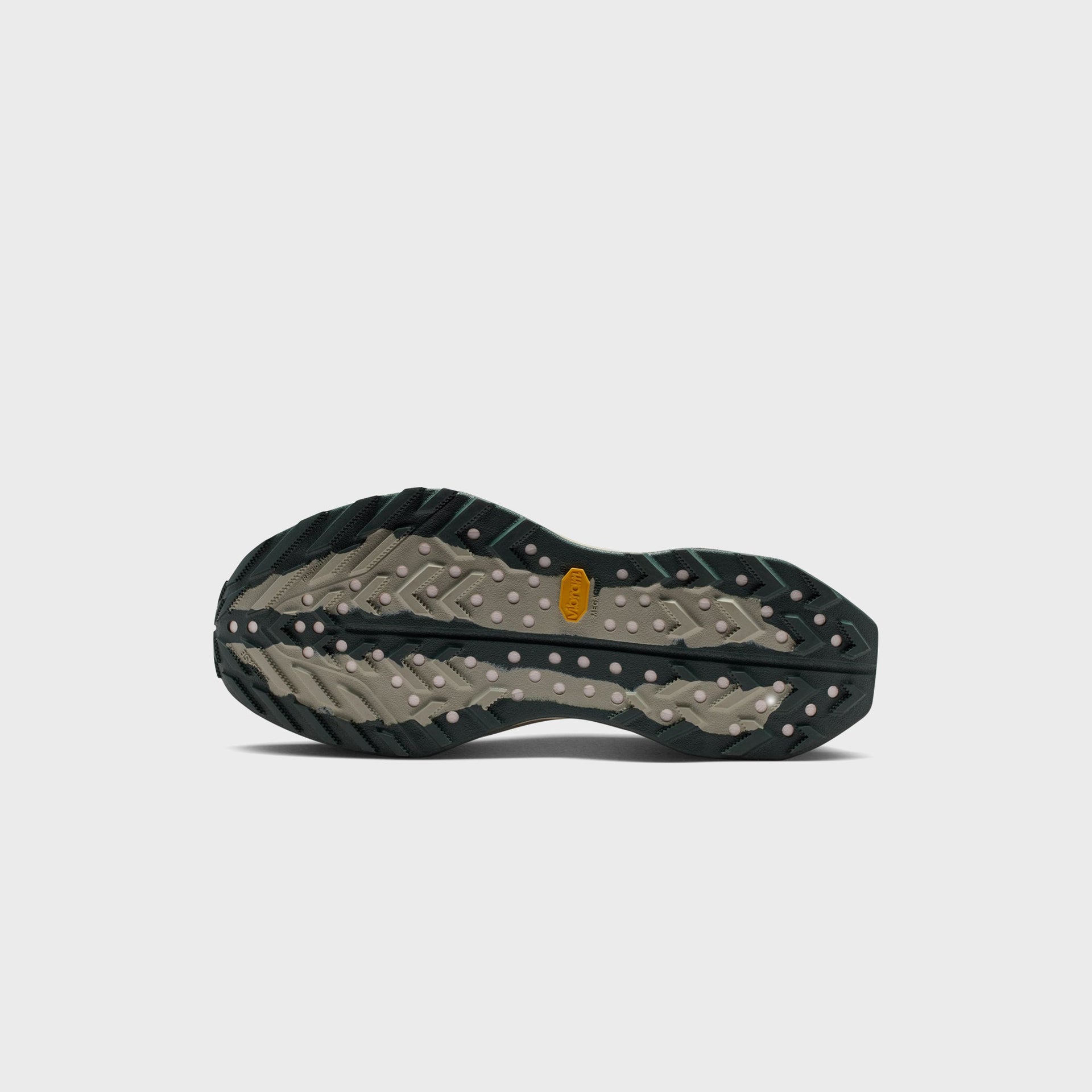 Nike ACG Ultrafly Trail running shoe outsole showing tan and black spruce Vibram Megagrip lugged tread pattern
