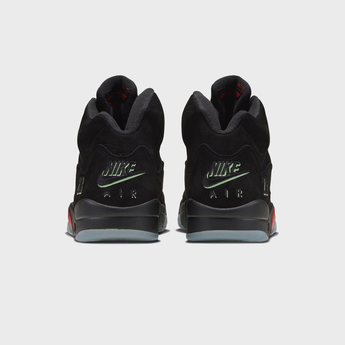 Rear view of Jordan Air Jordan 5 Retro black with green Nike Air heel branding and icy translucent sole