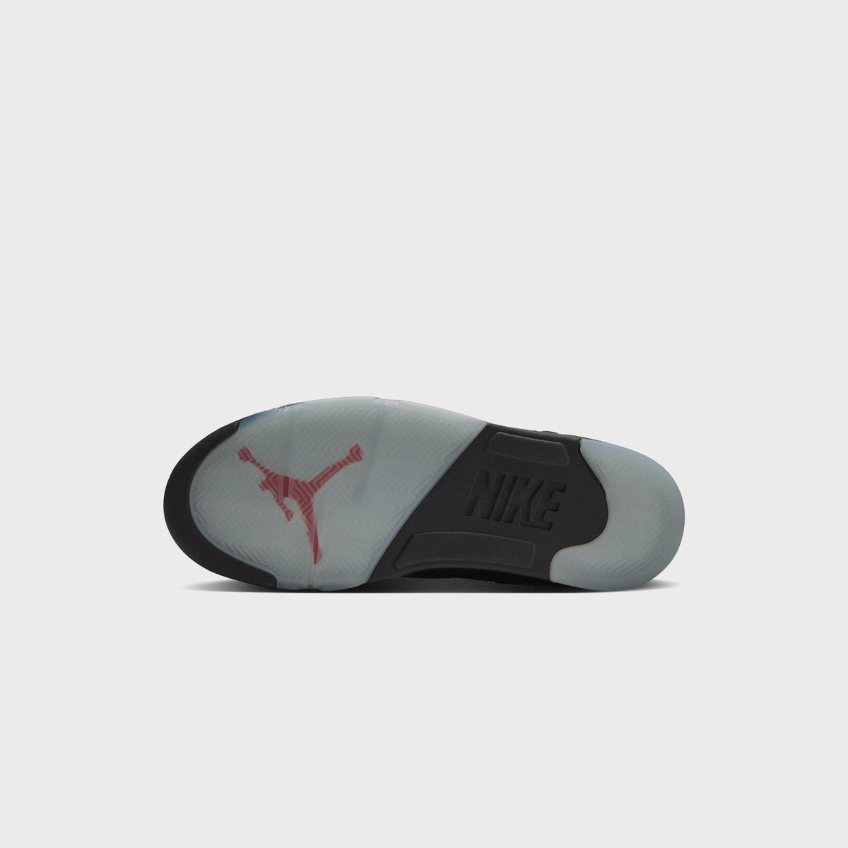 Outsole of Jordan Air Jordan 5 Retro with red Jumpman logo, icy translucent tread and black Nike heel