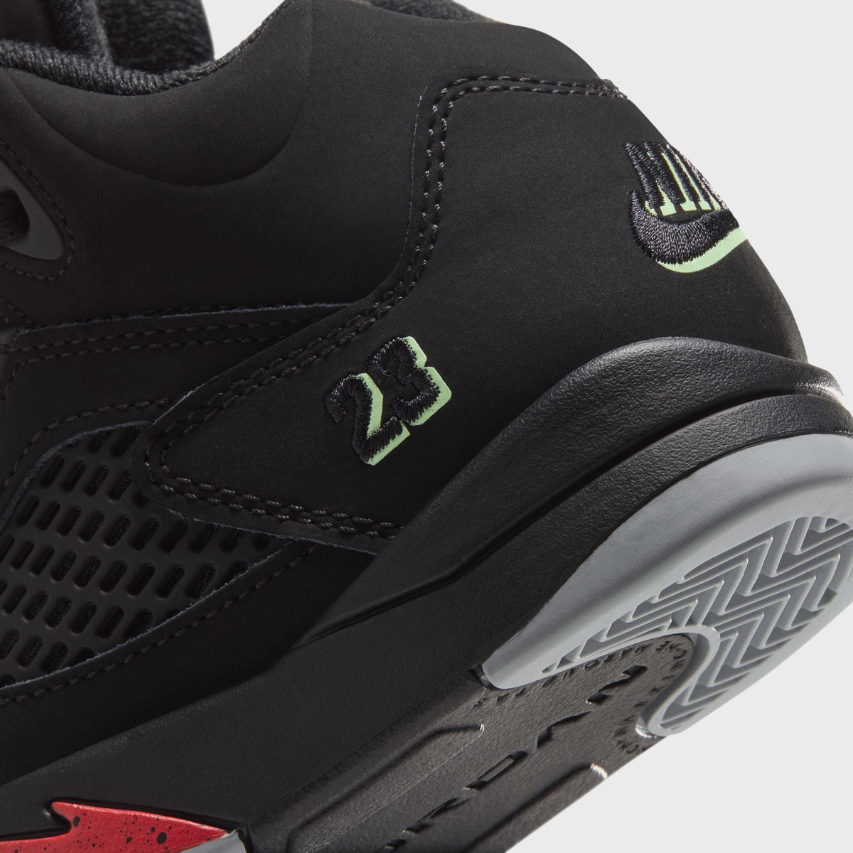 Close-up of Jordan PS Jordan 5 Retro heel with green Nike swoosh and 23 detail above grey herringbone sole