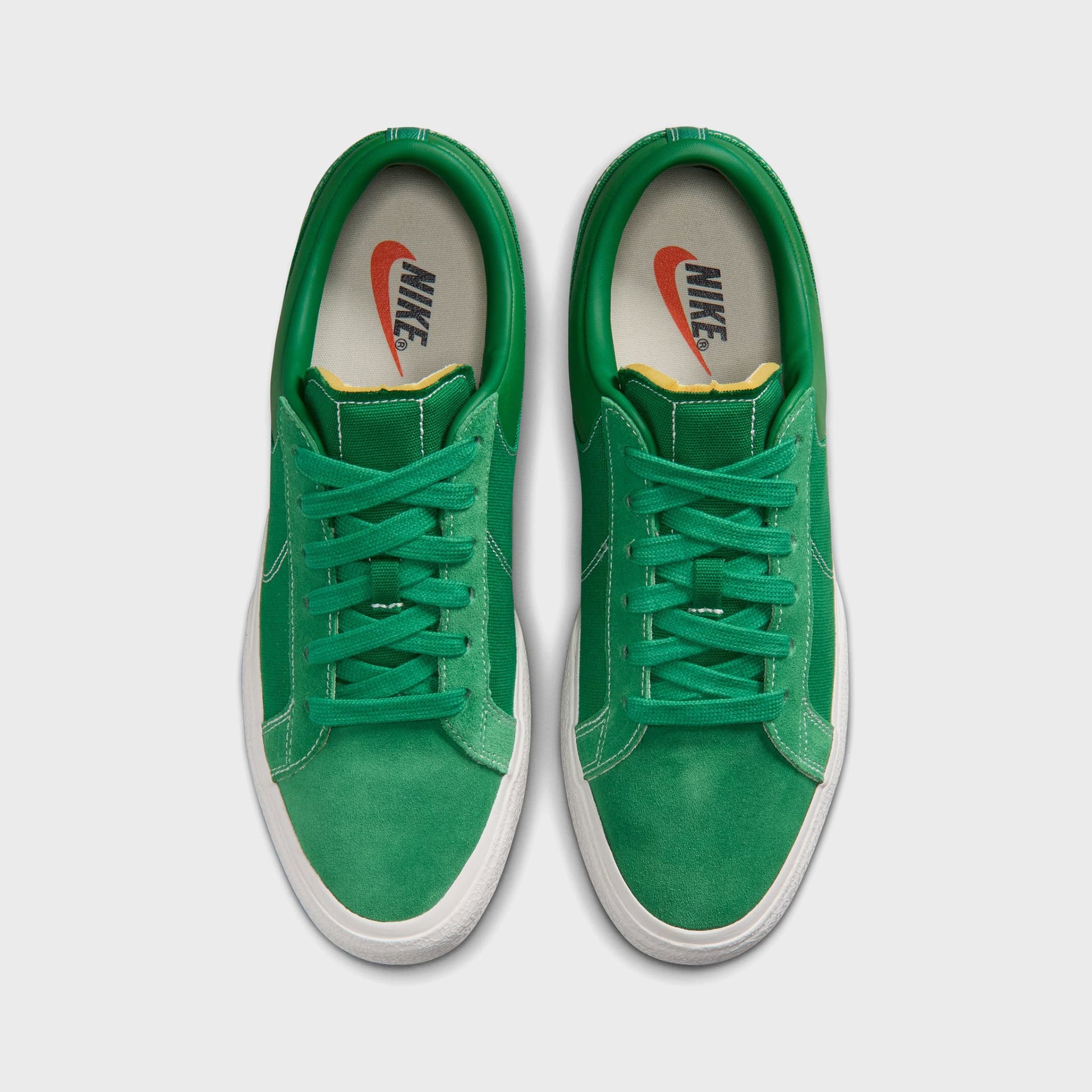 Overhead top-down view of the Nike Blazy Pine Green pair with cream insoles and vintage orange Nike Swoosh branding