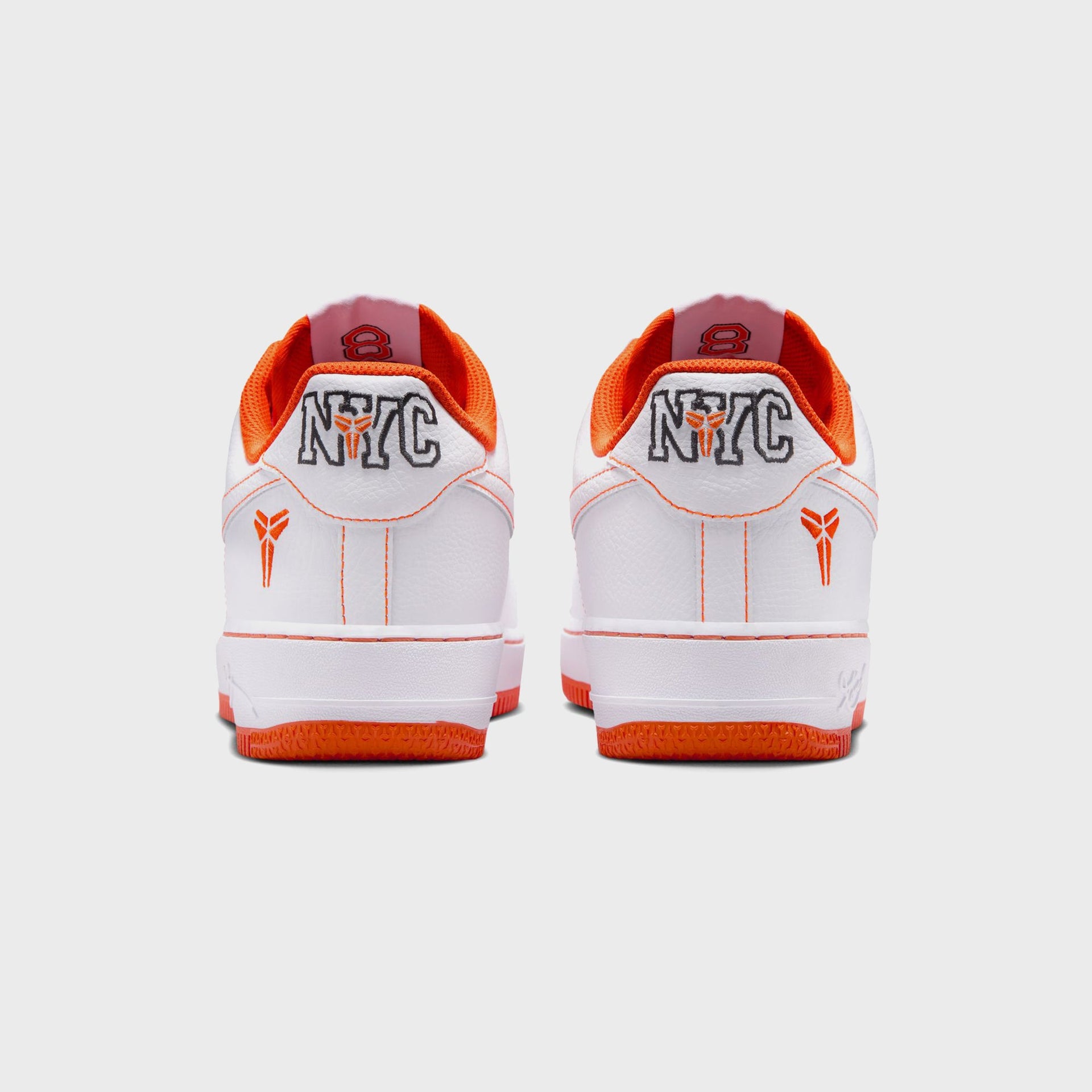 Rear view of the Nike AF1 Low Protro NYC in white with orange Kobe sheath heel logo, NYC embroidery and orange outsole