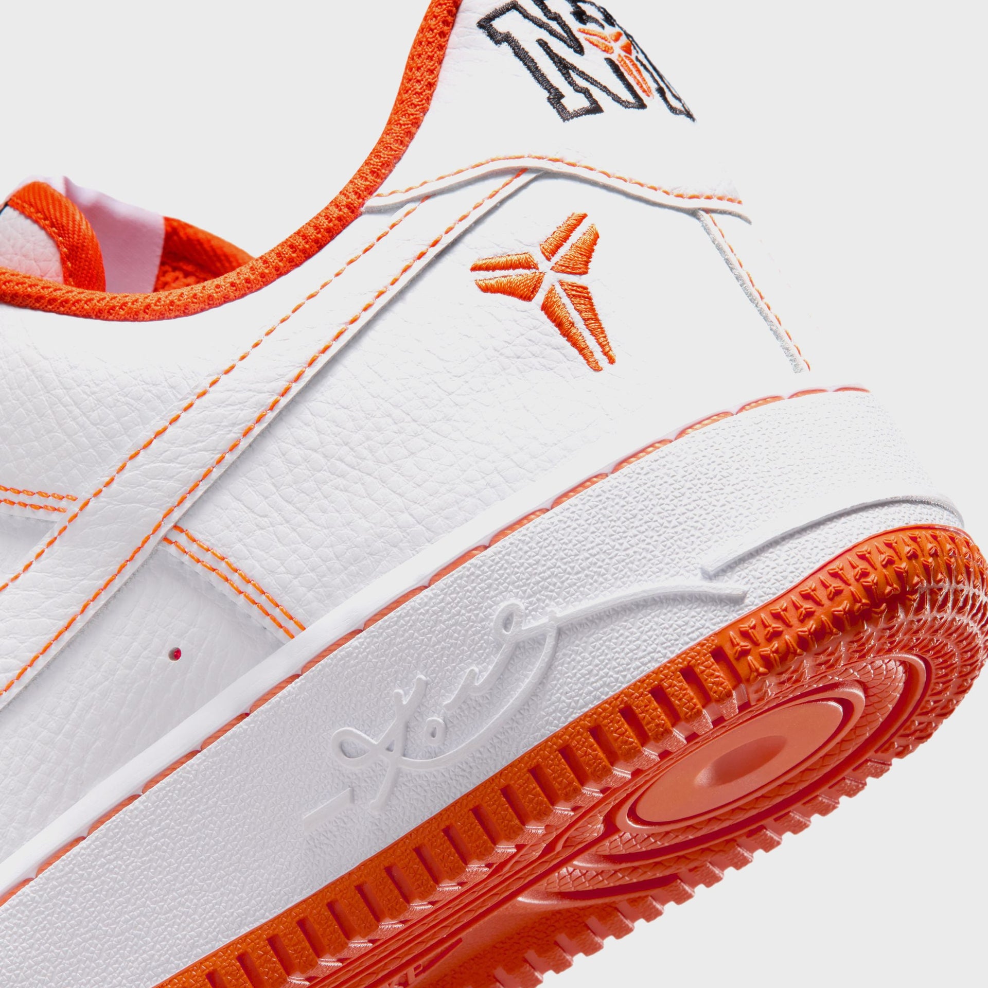 Detail of the Nike AF1 Low Protro NYC orange Kobe sheath heel logo and debossed Kobe signature on the white midsole