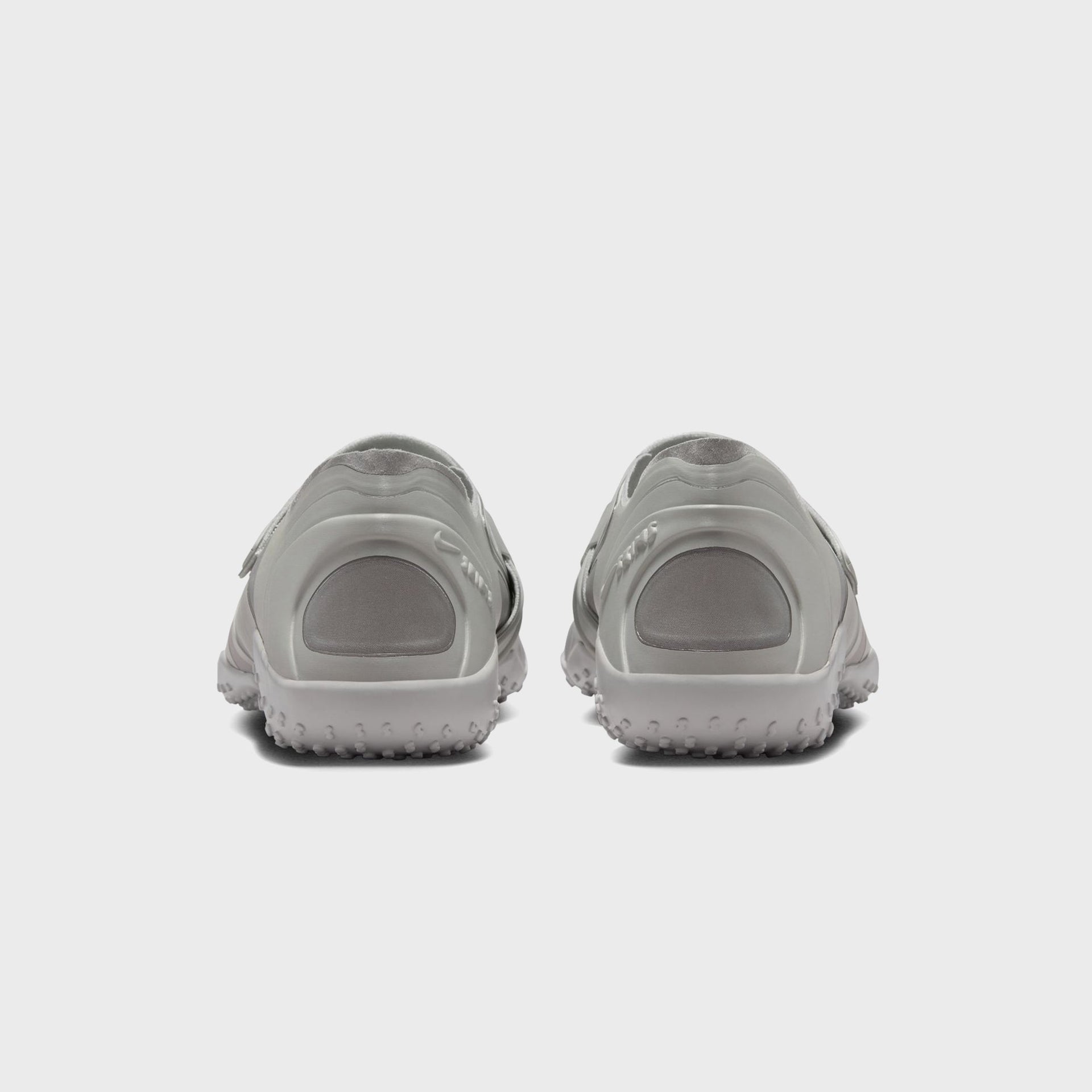 NikeSKIMS Rift Satin sneakers in Night Silver, rear heel view of the pair with sculpted grey heel counters and studded outsole