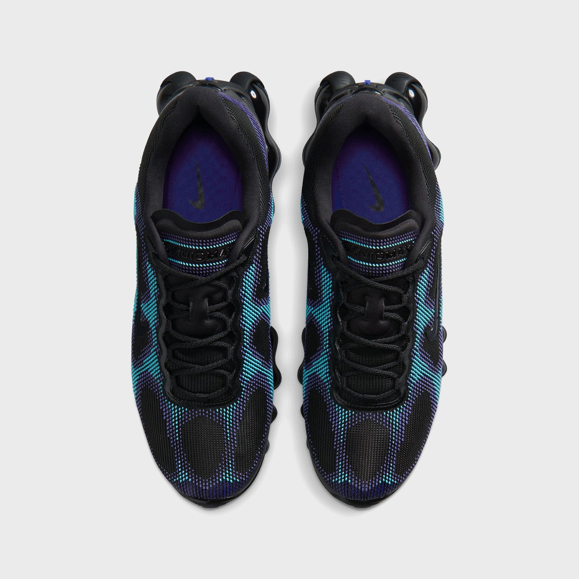 Top-down view of Nike Air Liquid Max sneakers showing black laces, purple insole lining and Swoosh detail