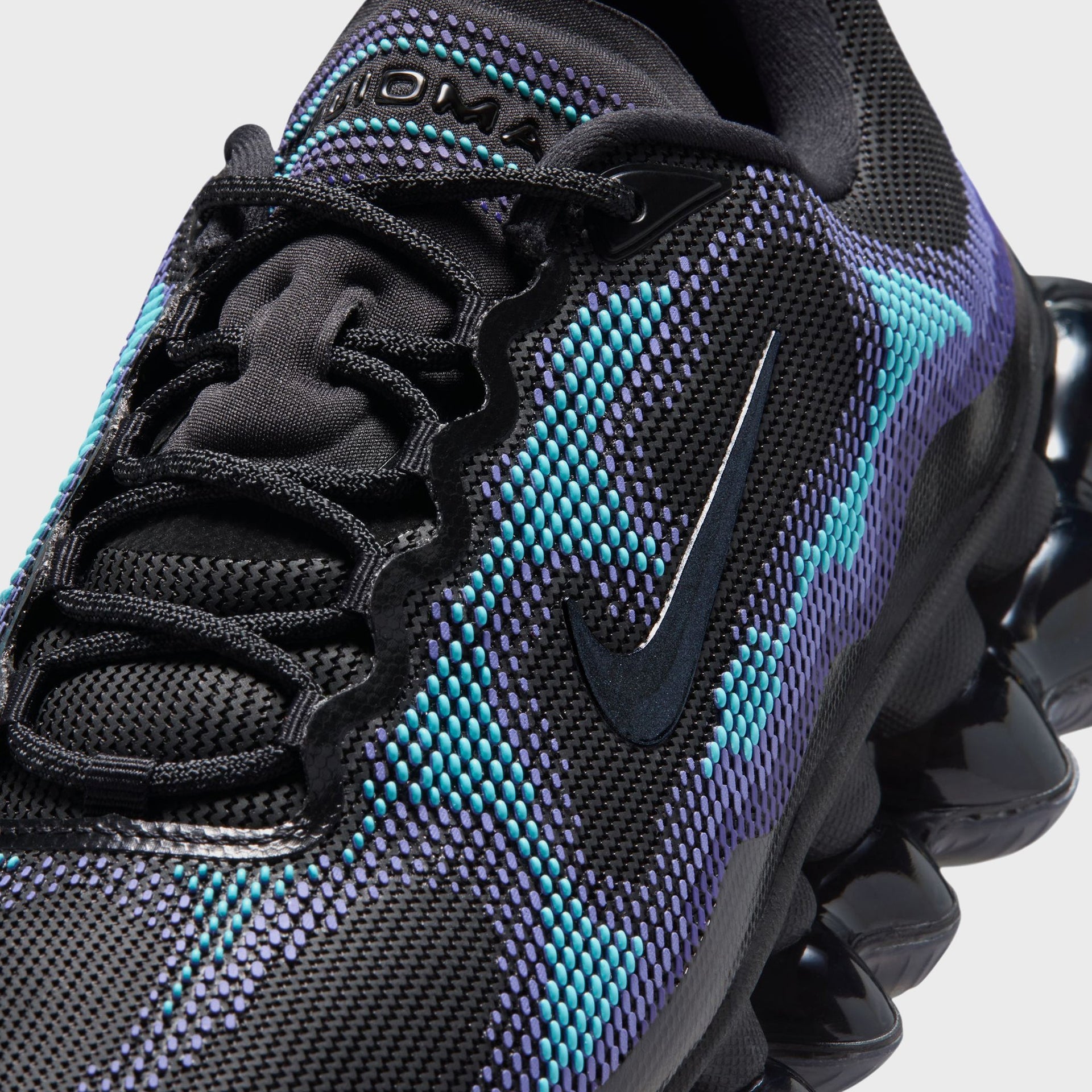 Close-up of the Nike Swoosh and purple-teal knit upper on the forefoot of the Air Liquid Max sneaker