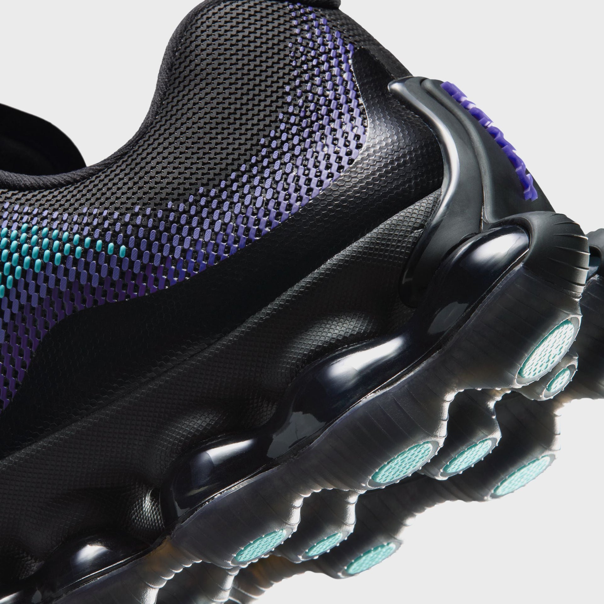 Close-up angled view of the Nike Air Liquid Max heel and midsole, showing knit upper texture and teal-accented traction pods