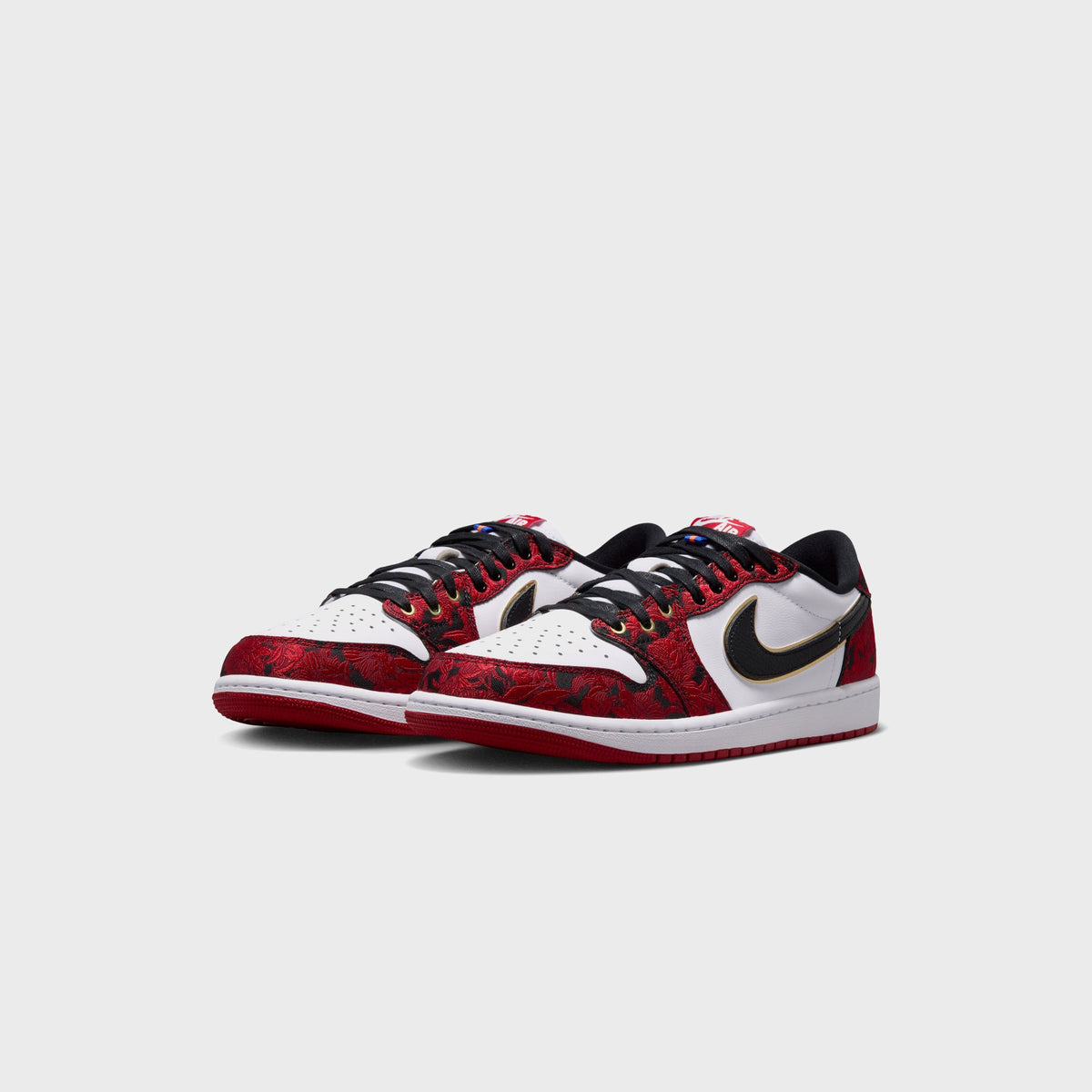 Angled front pair view of Air Jordan 1 Low OG in white, black and red floral embroidery with gold Swoosh outline and black laces