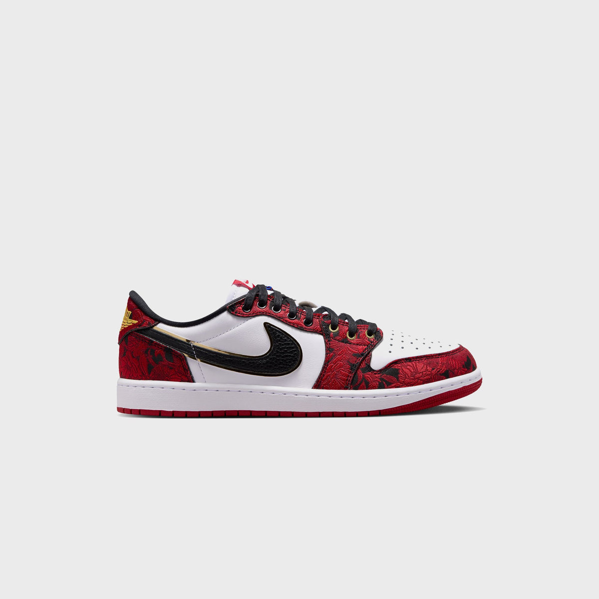 Air Jordan 1 Low OG sneaker in white and black leather with red floral-embroidered overlays, black laces, and gold trim, side profile view
