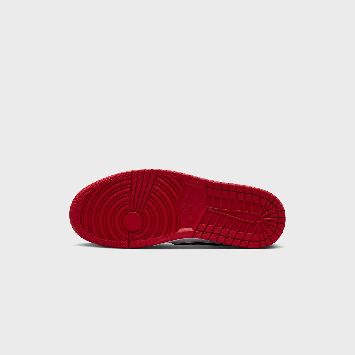 Bottom view of Air Jordan 1 Low OG outsole in red rubber with circular heel pivot pattern and Nike Air branding