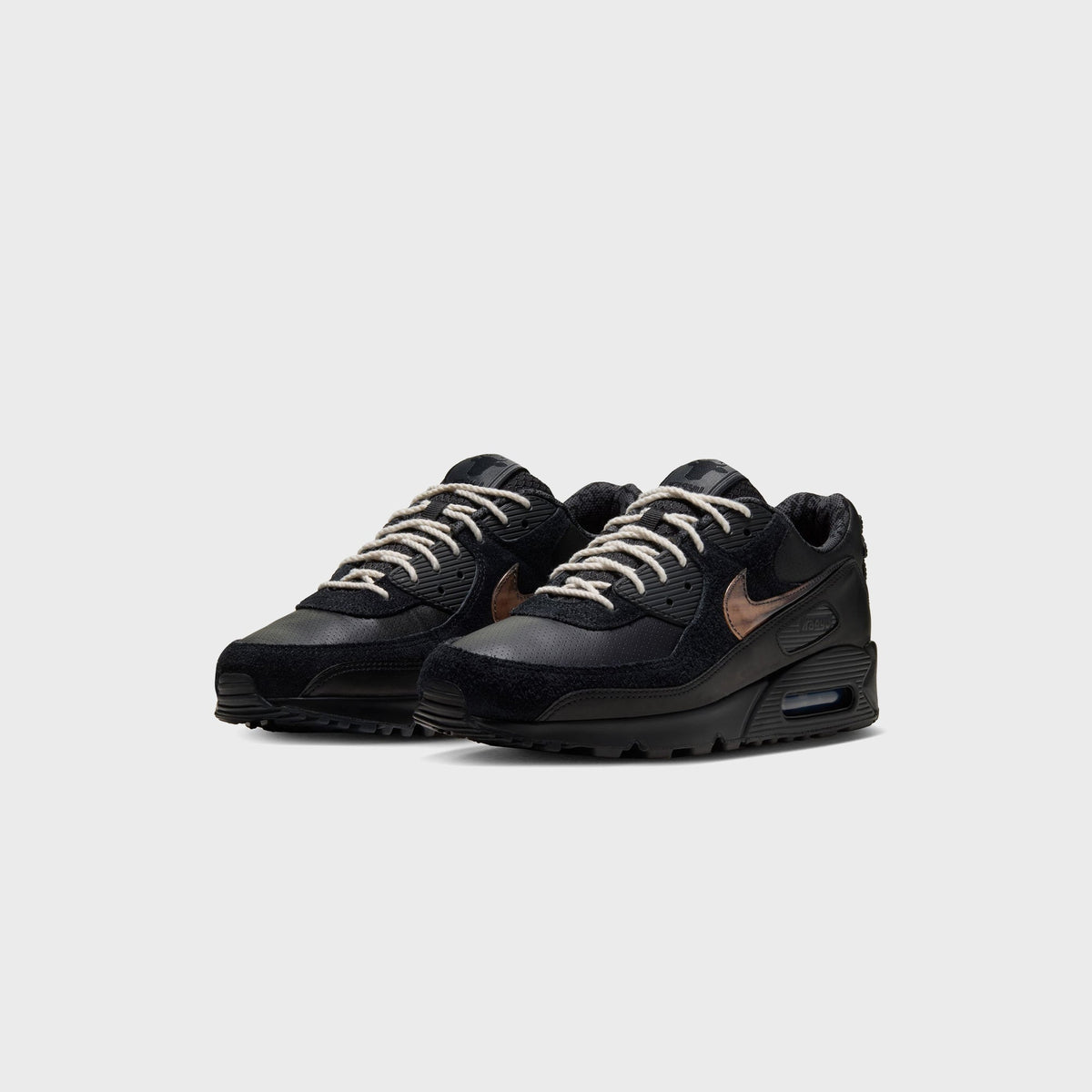 Pair of Nike x Wagyu Air Max 90 sneakers in black, angled front view showing off-white laces and Wagyu ankle tag