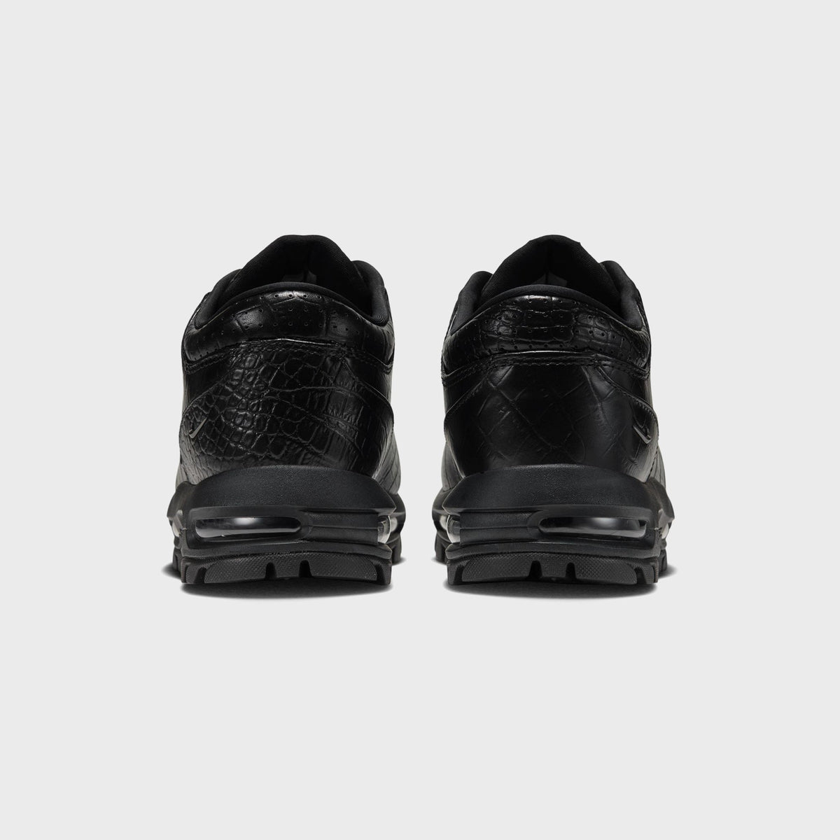 Nike Air Max Goadome Low black, rear view of pair showing heel Air unit and textured leather