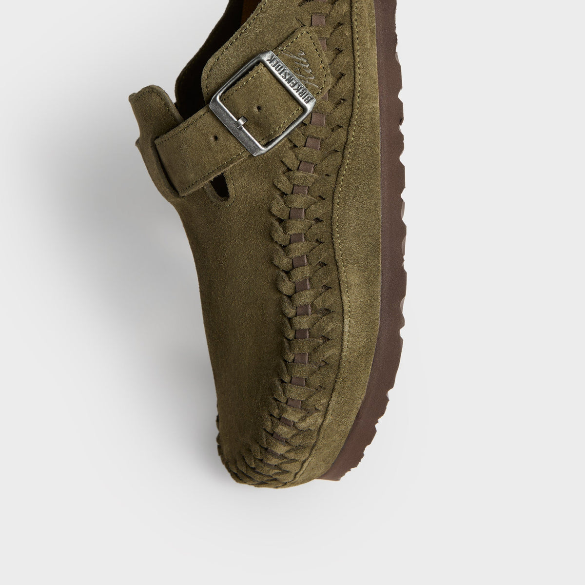 Kith for Birkenstock Boston Braided in Thyme, angled close-up of the buckle strap, braided edge and brown sole