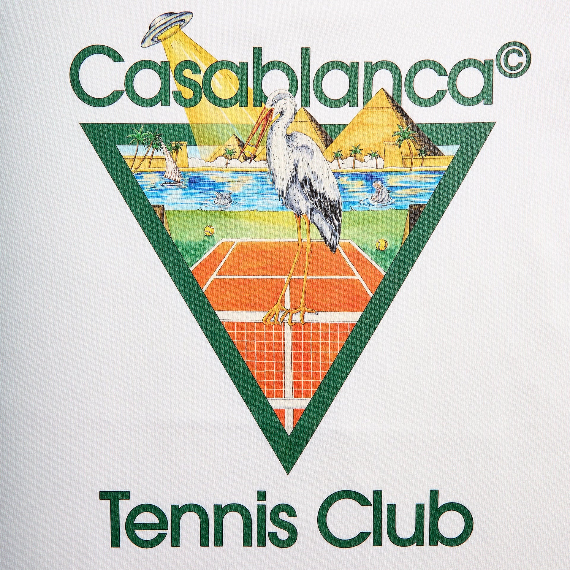 Close-up of Tennis Club graphic on white: stork on a clay court, pyramids, palm oasis and a UFO beaming down