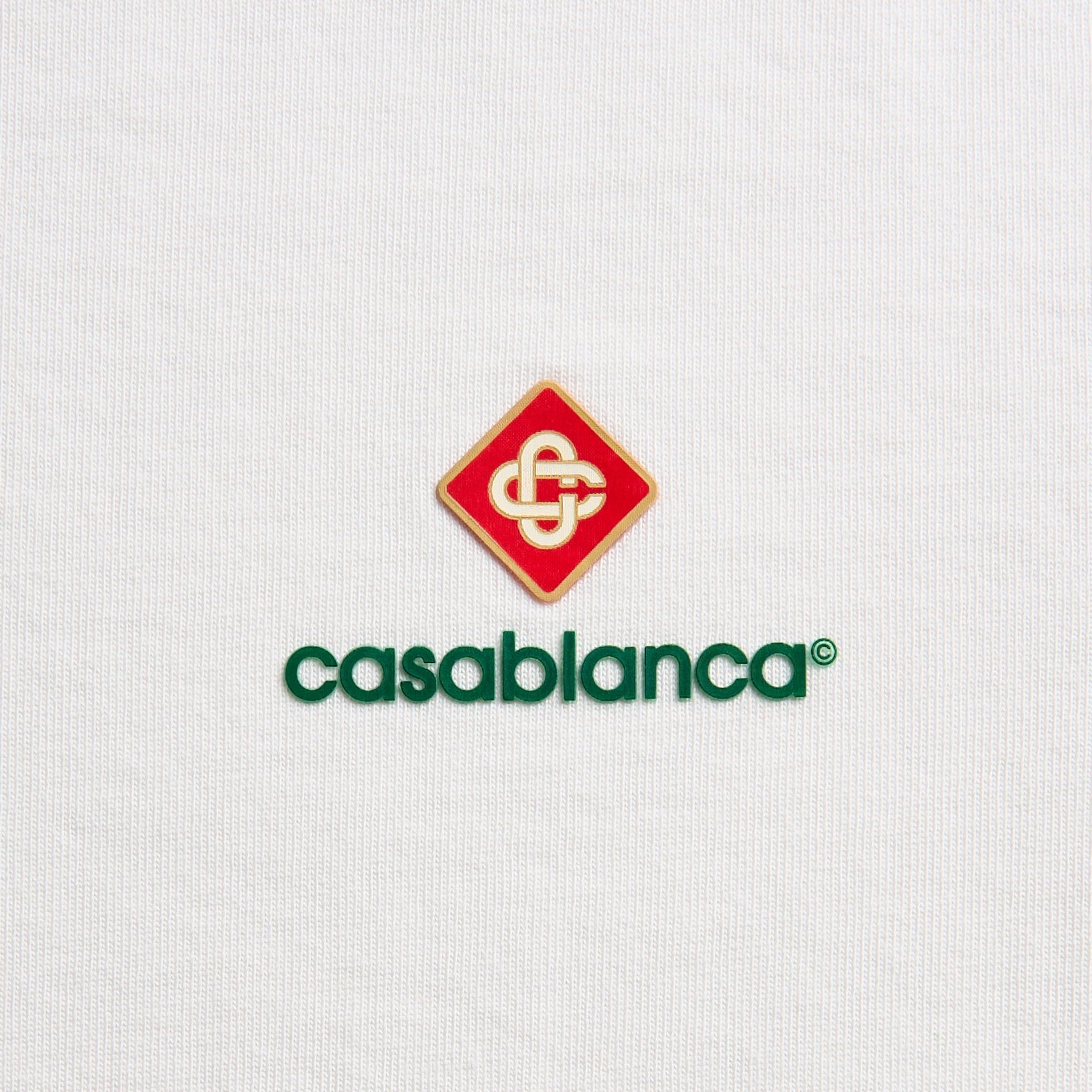 Close-up of Sport Type logo: red diamond crest with interlocked monogram above green casablanca lettering