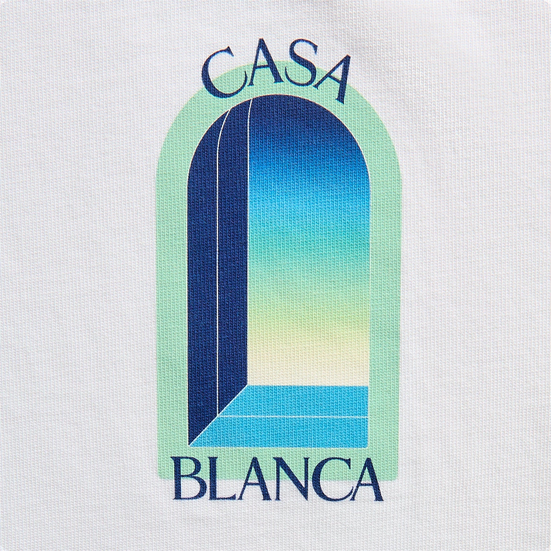 Close-up of L'Arche graphic on white: green-framed blue and yellow ombre archway doorway with Casa Blanca lettering