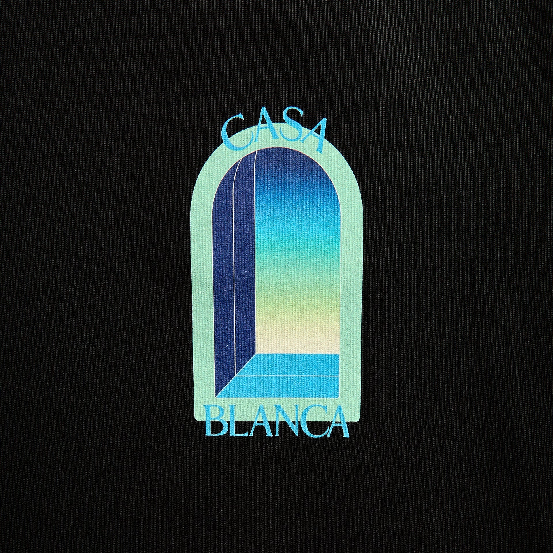 Close-up of L'Arche graphic: blue, green and yellow ombre archway doorway with Casa Blanca lettering