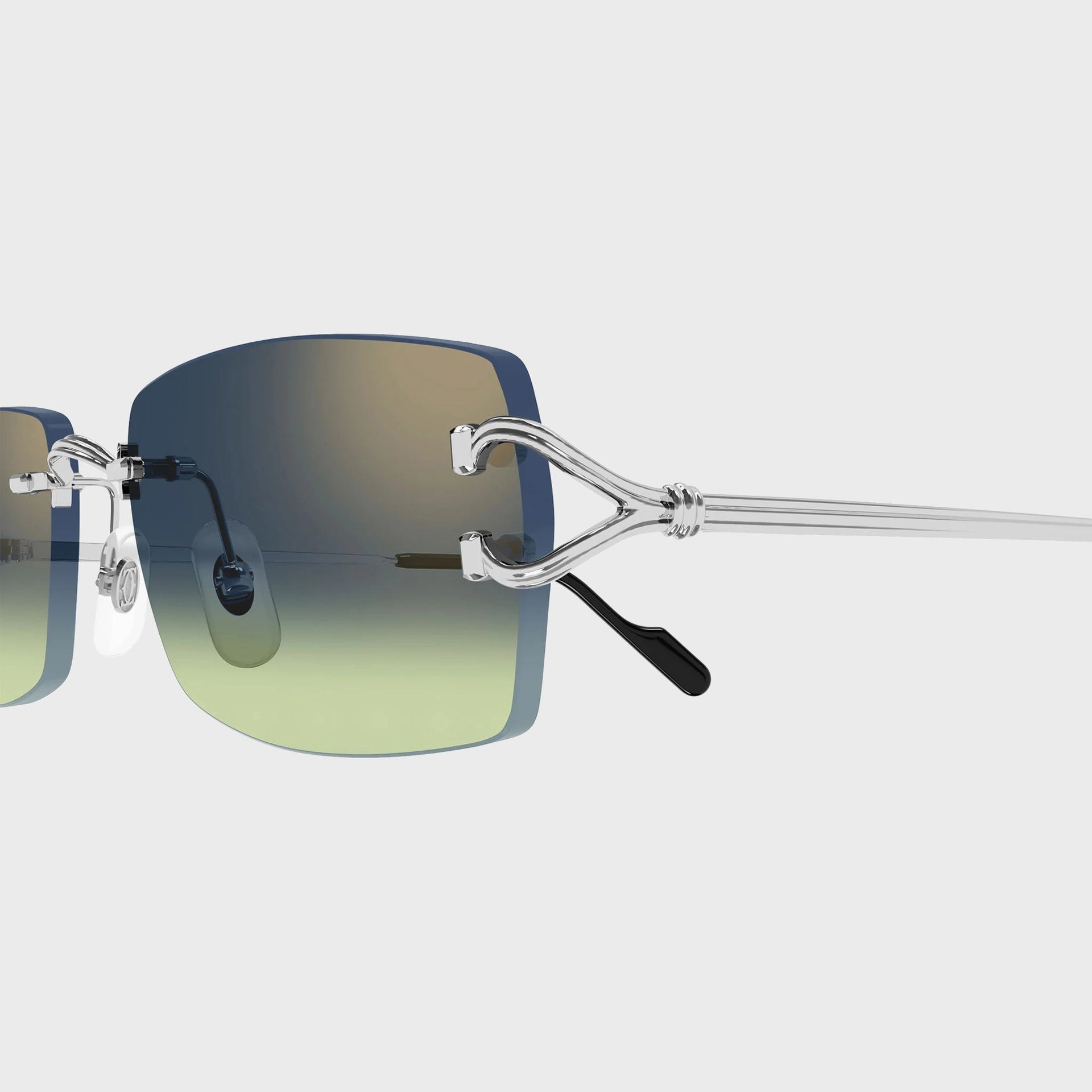 Close-up of the silver C-shaped temple hinge and blue-green gradient lens on Cartier Decor C sunglasses