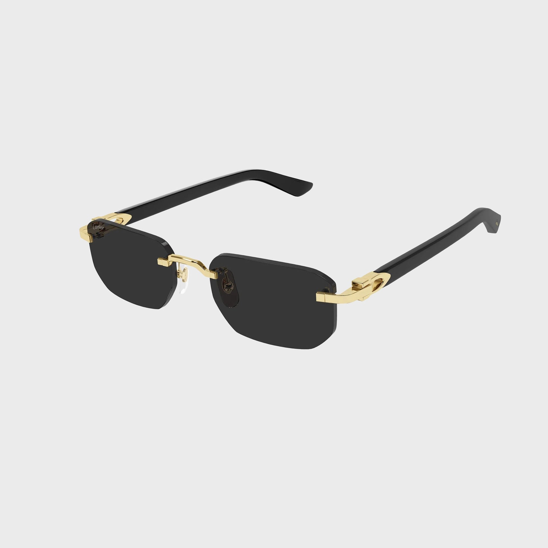 Cartier Decor C rimless rectangular sunglasses with gold hardware, dark grey lenses and black temple arms, angled view