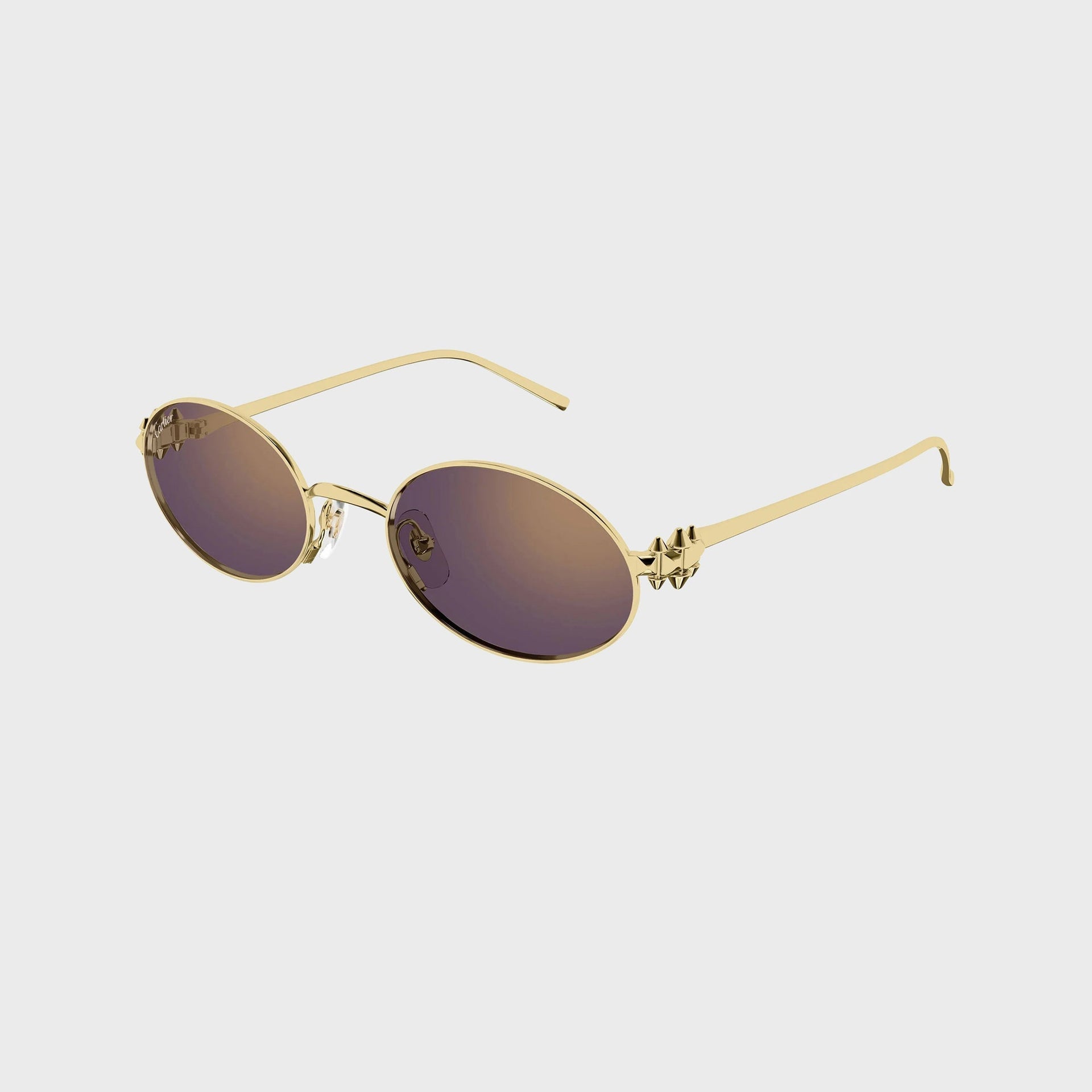 Cartier Clash CT0644S gold oval sunglasses with violet-brown gradient lenses, angled view showing the studded gold spike temple detail
