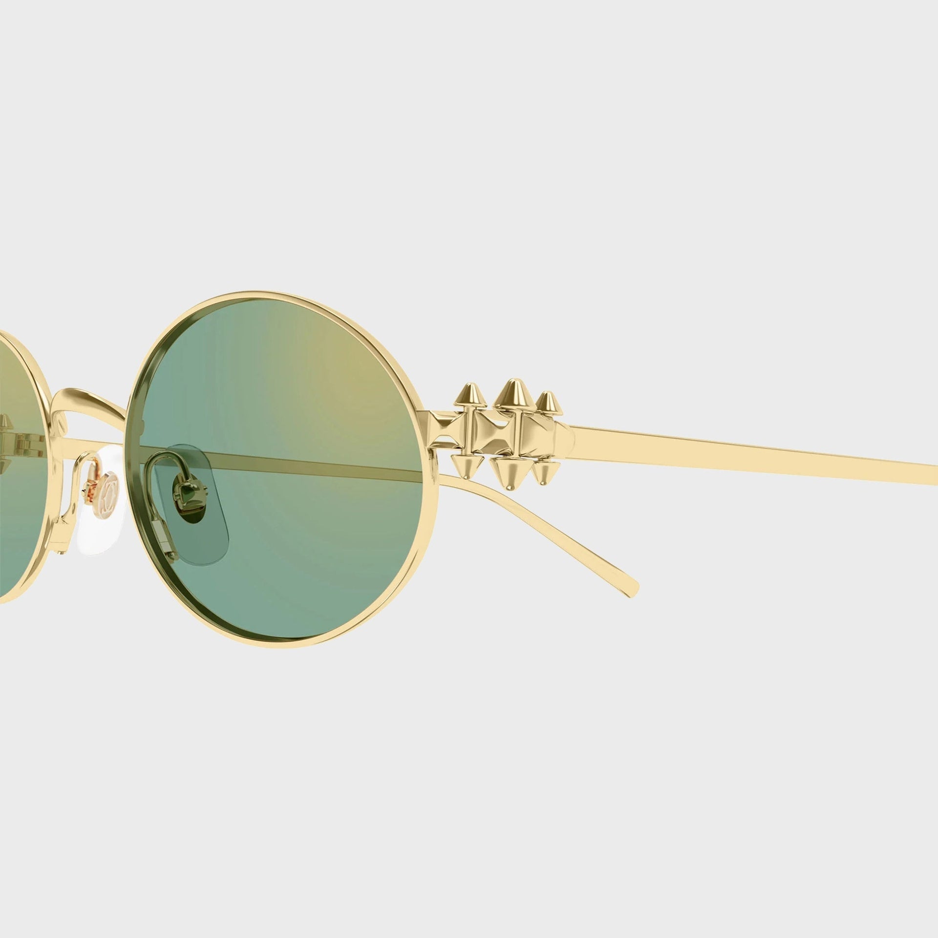 Close-up of the gold pyramid-stud temple and green gradient lens on Cartier Clash CT0644S sunglasses
