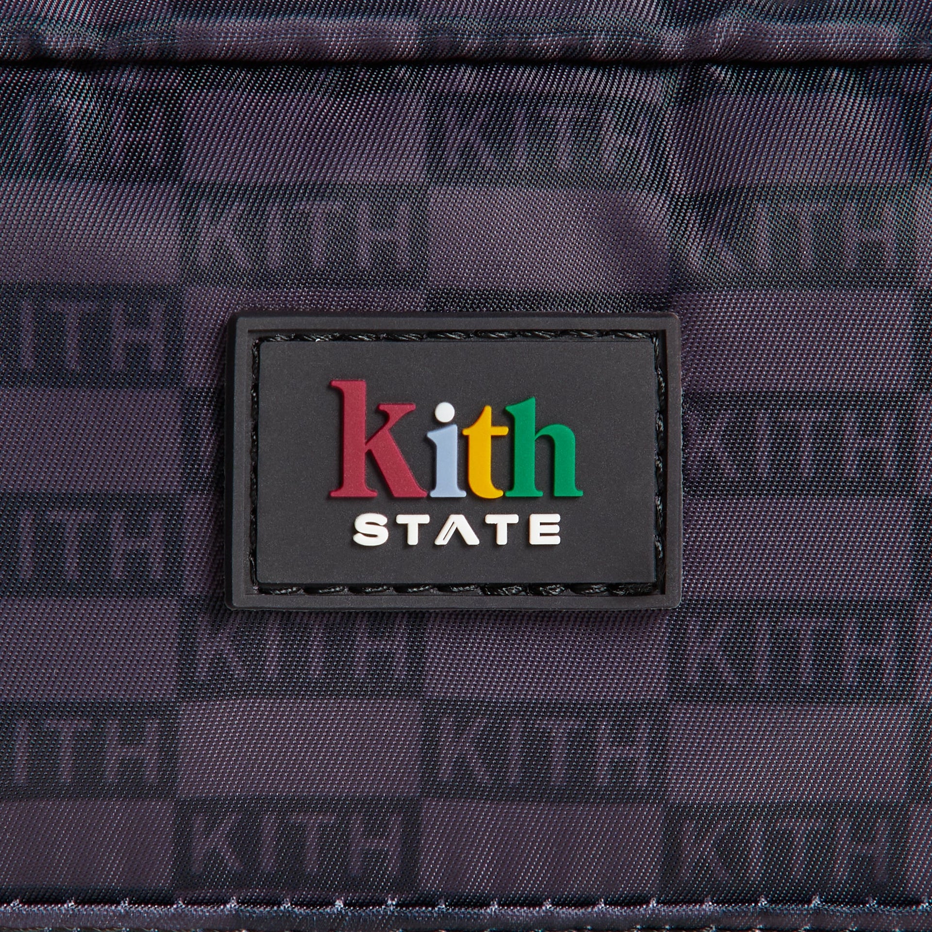 Close-up of colorful Kith STATE rubber logo patch on Black KITH monogram Clinton Pencil Case