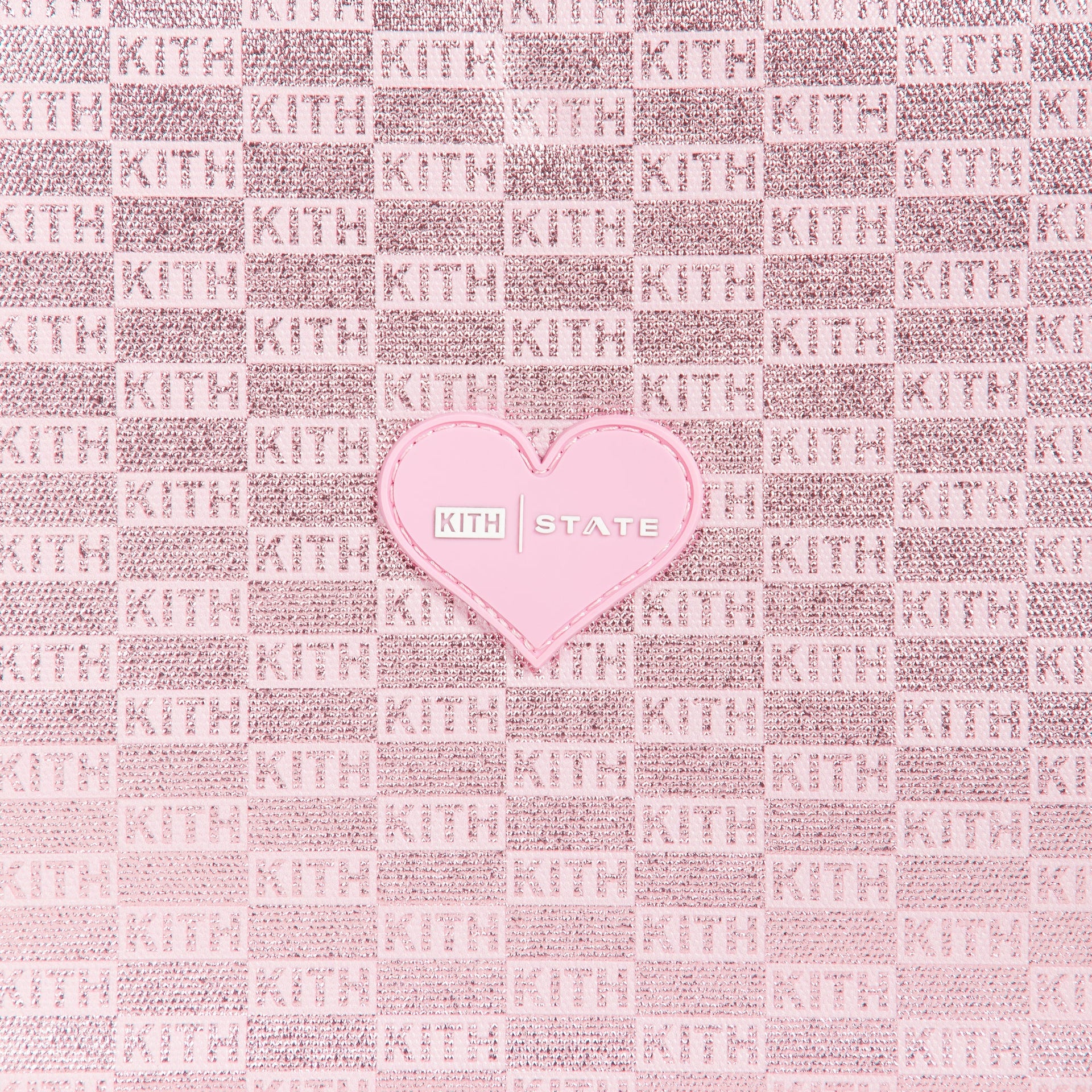 Close-up of pink metallic KITH checkerboard monogram fabric with heart KITH STATE patch on Rodgers Lunch Box