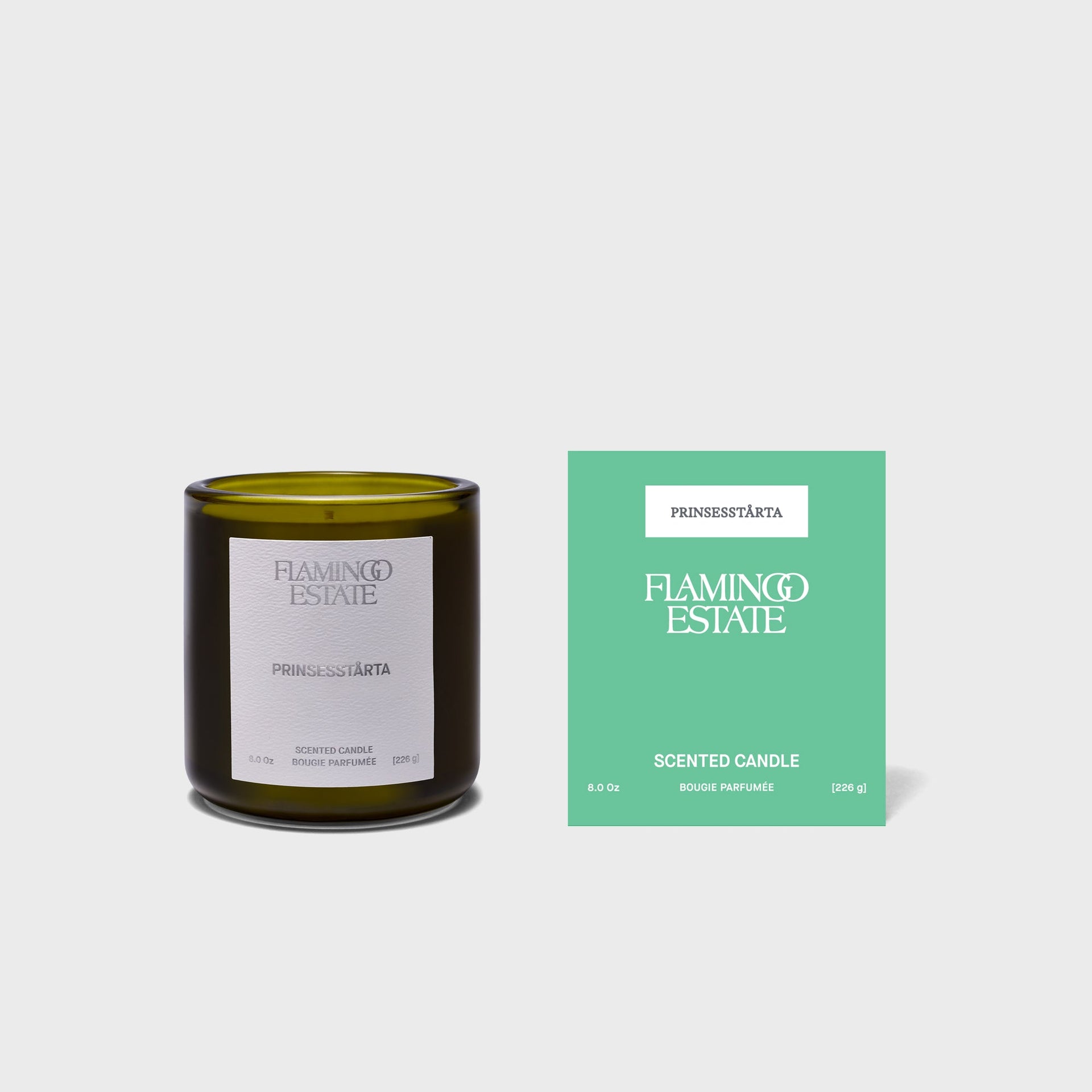 Flamingo Estate Prinsesstärta candle in olive glass with white label beside mint-green gift box, 226g