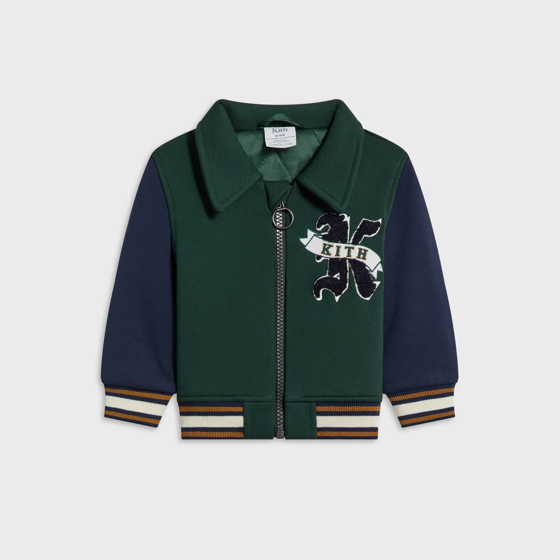 Kith Baby Varsity Jacket in Stadium colorway, flat lay front view with green wool body, navy sleeves and embroidered K Kith crest patch