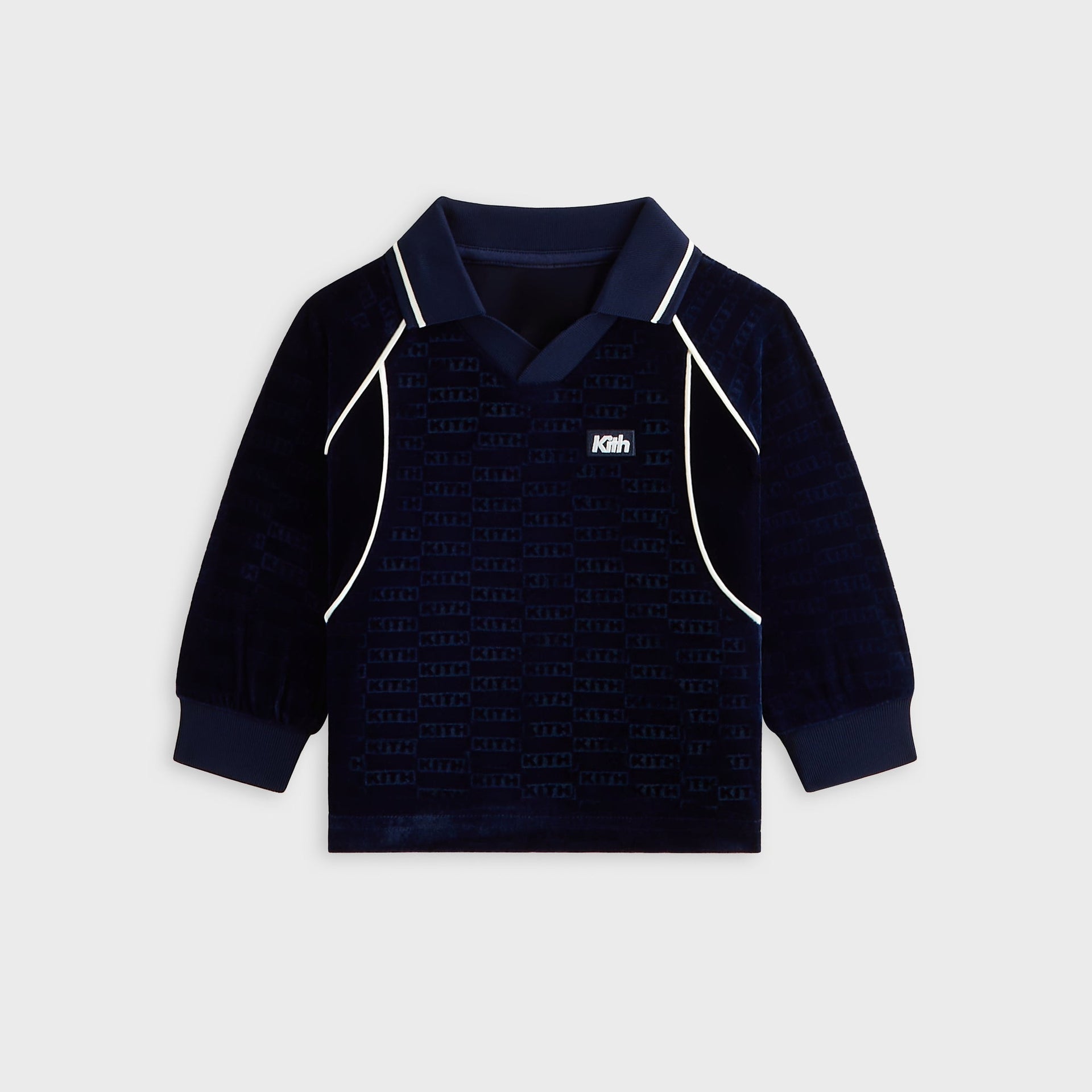 Kith Baby Long Sleeve Soccer Jersey Polo in navy Nocturnal velour, front flat lay with collar, cream piping and Kith patch